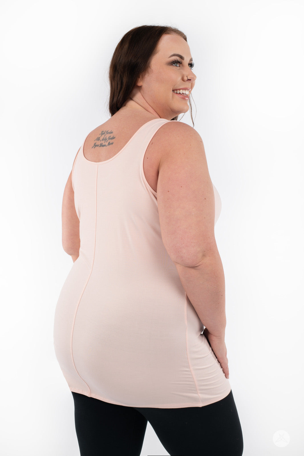 Plus-size model smiling wearing SweetLegs Canada Classic Layering Tank in pale pink with a smooth, form-fitting back view