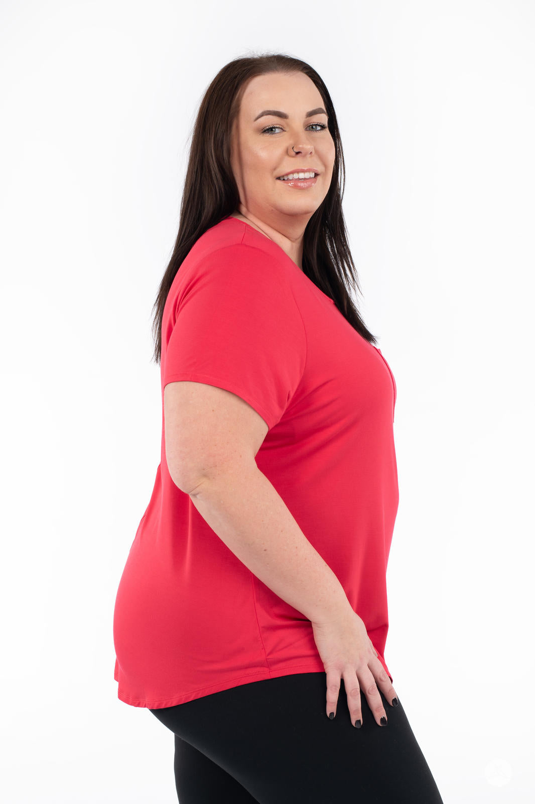 Woman smiling wearing SweetTops Crew Neck Pocket Tee in bright red with short sleeves and relaxed fit from side view