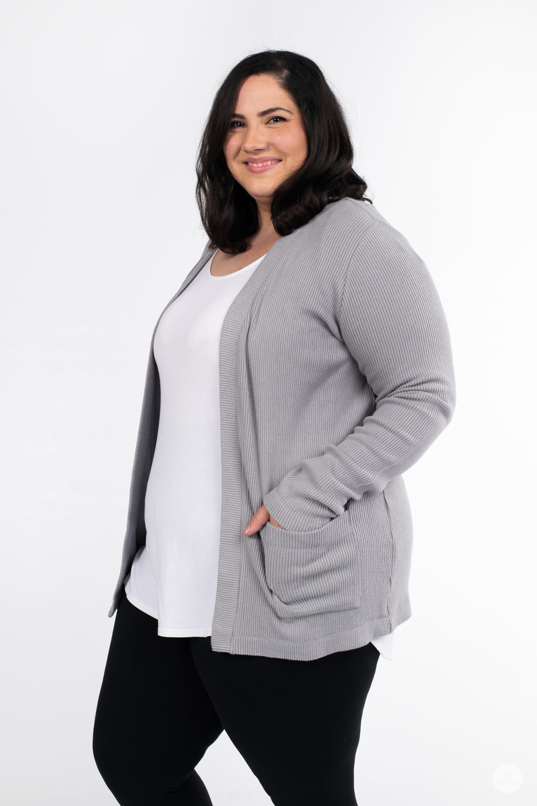 Smiling plus-size woman wearing SweetLegs Canada Ribbed Comfort Cardigan in soft grey with open front and side pockets