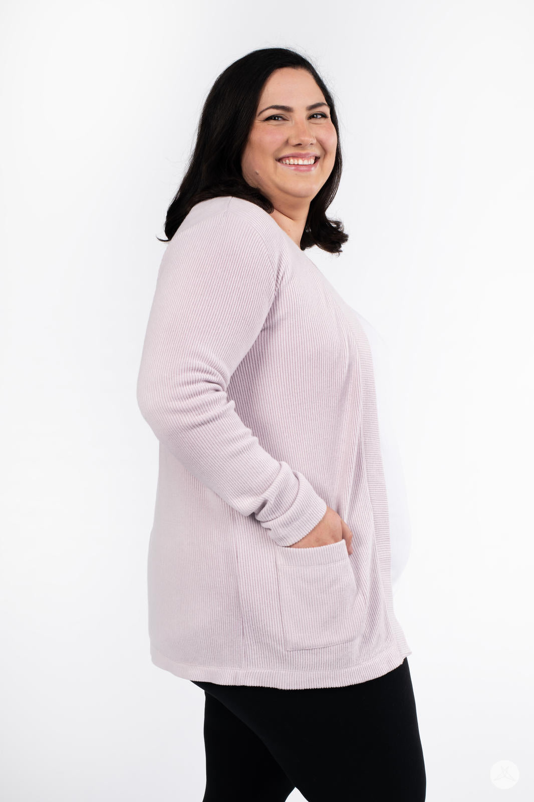 Side view of plus-size woman wearing SweetLegs Canada Ribbed Comfort Cardigan in soft pink with front pocket detail