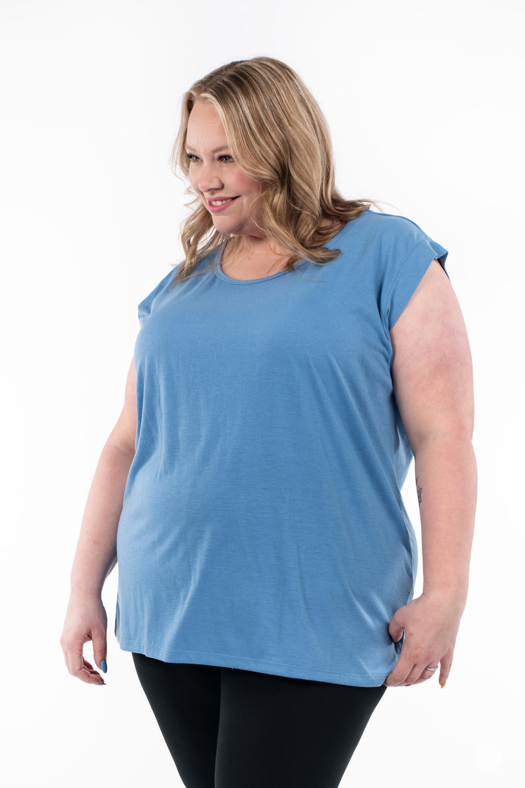 Plus-size woman wearing blue Cap Sleeve Scoop Neck Tee by SweetTops smiling and looking down on white background