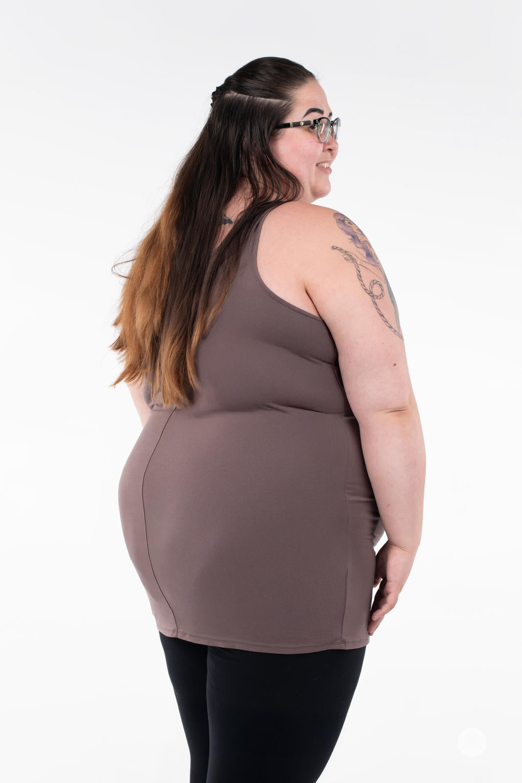 Plus-size woman showing back of SweetLegs Canada Classic Layering Tank in brown paired with black leggings on white background