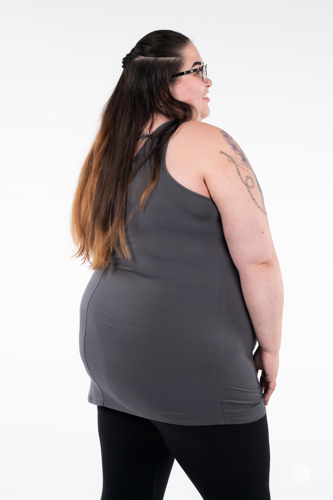 Plus-size woman with tattoo wearing SweetLegs Canada Classic Layering Tank in grey showing back view on white background