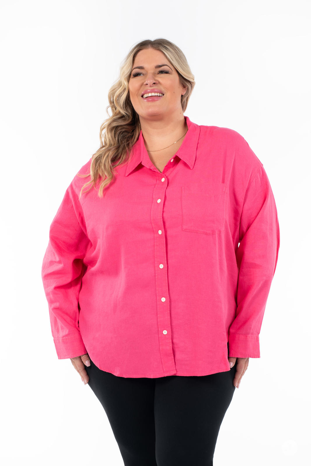 Plus-size model wearing SweetTops Classic Linen Shirt in bright pink with button front and chest pocket smiling on white background