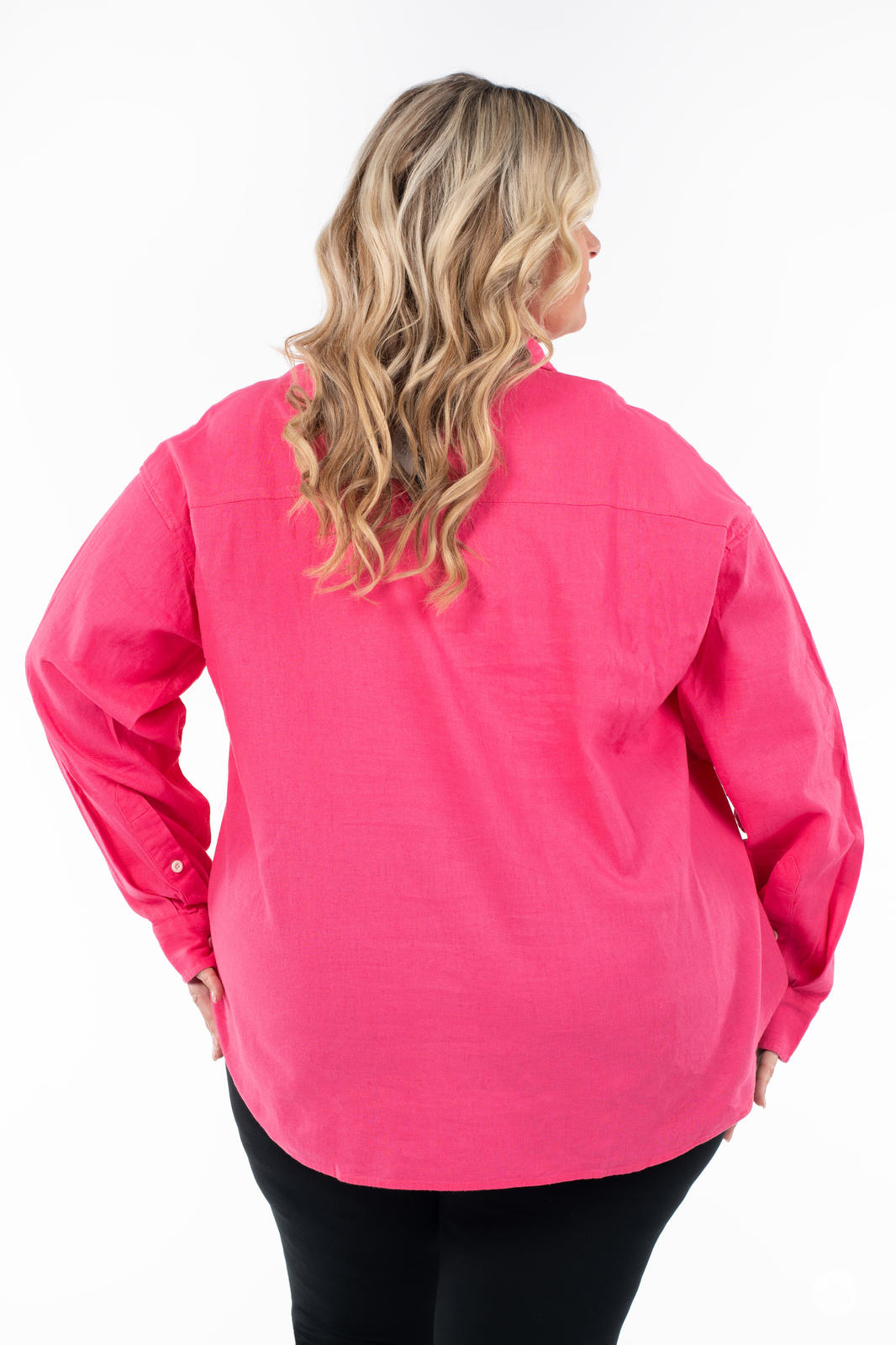 Plus-size model showing back of SweetTops Classic Linen Shirt in bright pink with long sleeves and relaxed fit