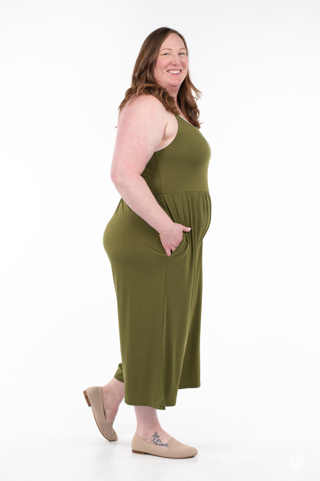 Plus-size model smiling wearing SweetLegs Cropped Wide Leg Jumpsuit in olive green with side pockets and sleeveless design