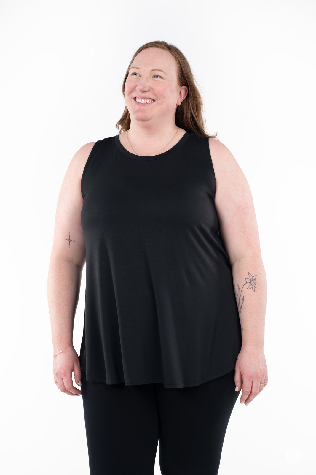 Smiling woman wearing SweetTops High Neck Swing Tank in black shown front on white background