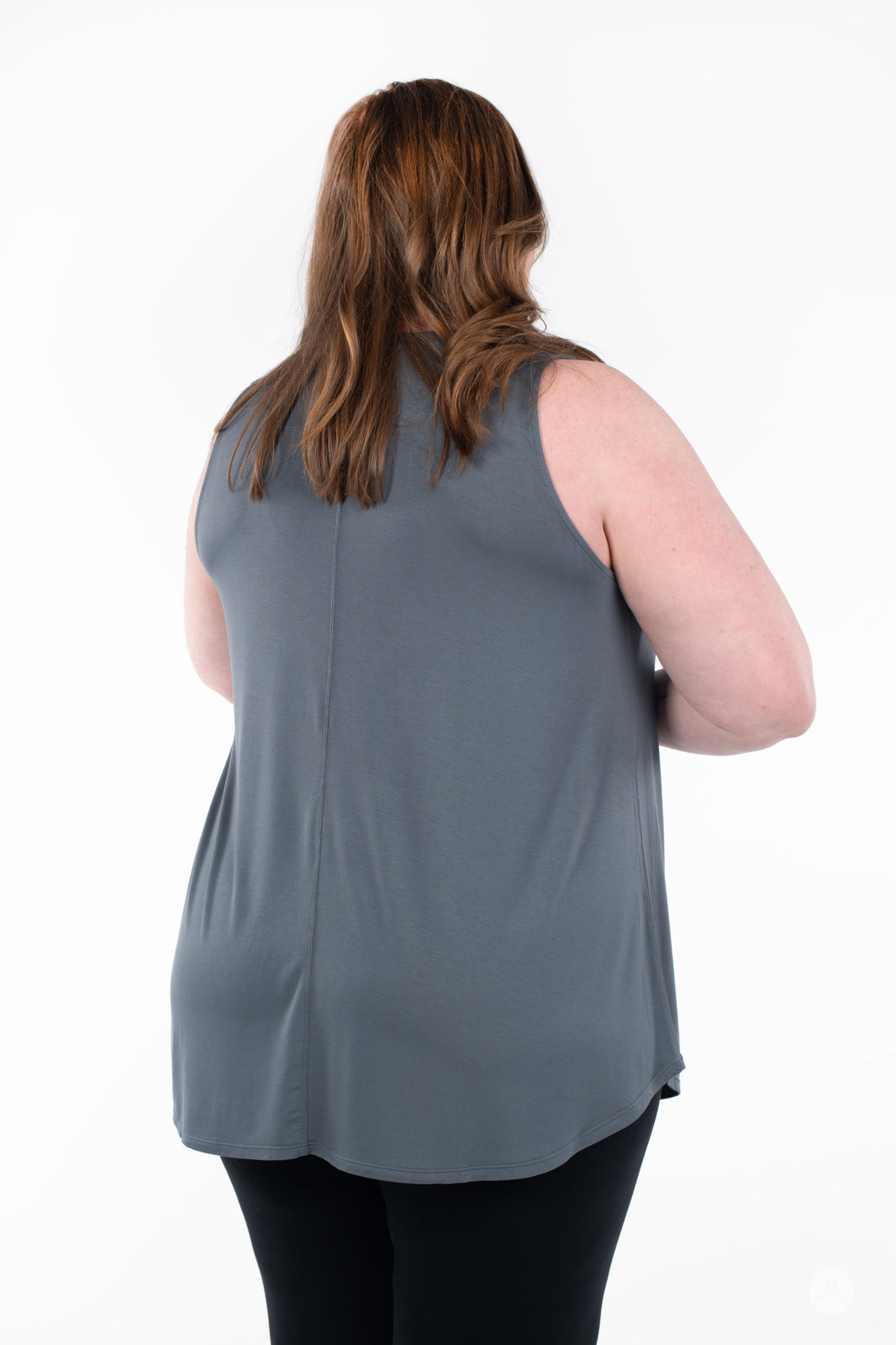 Plus-size model shown from back wearing SweetTops High Neck Swing Tank in muted gray with black pants on white background