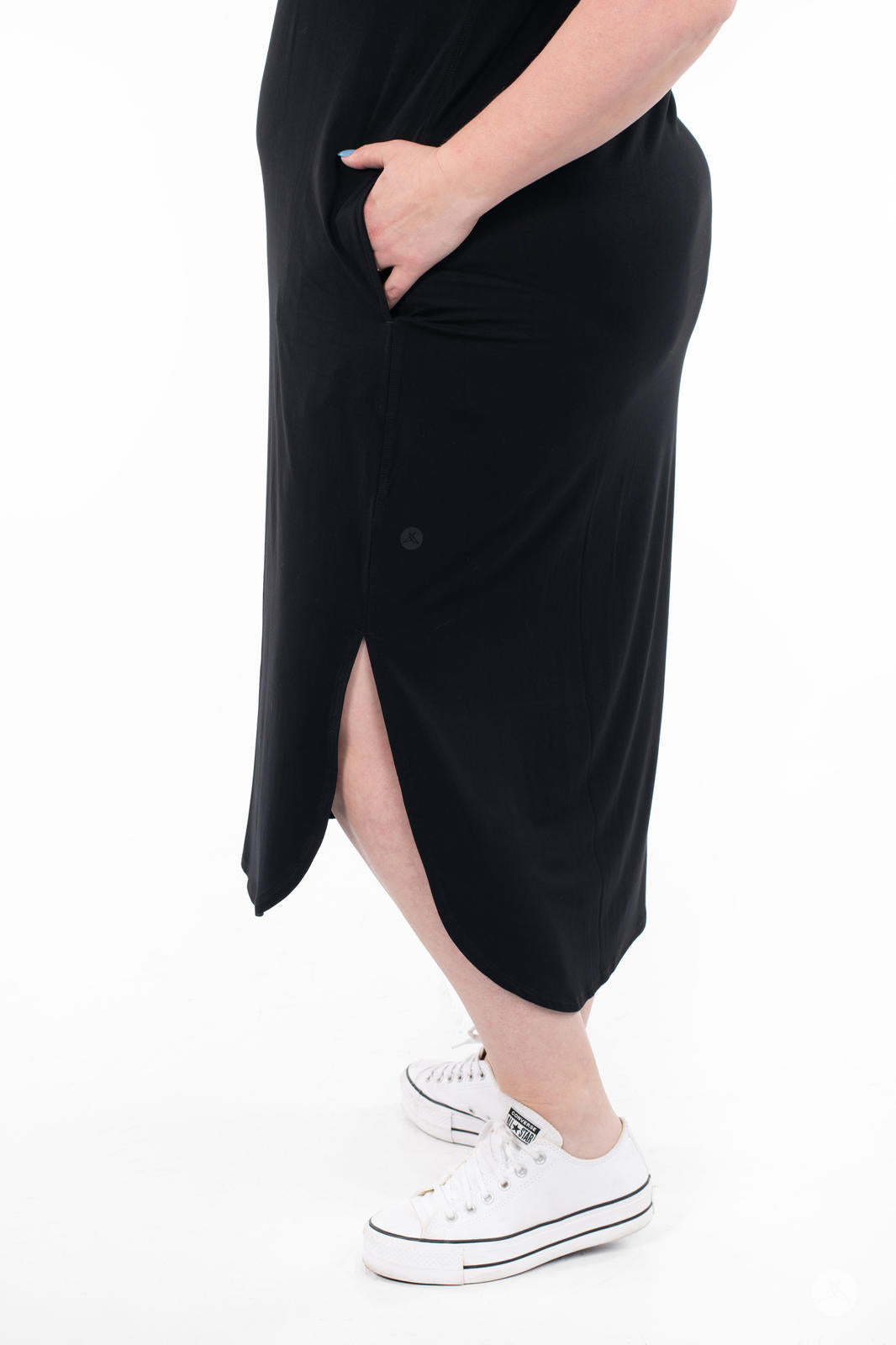 Side view of plus-size woman wearing SweetTops Sleeveless Tank Dress in black with side slit and pocket on white background