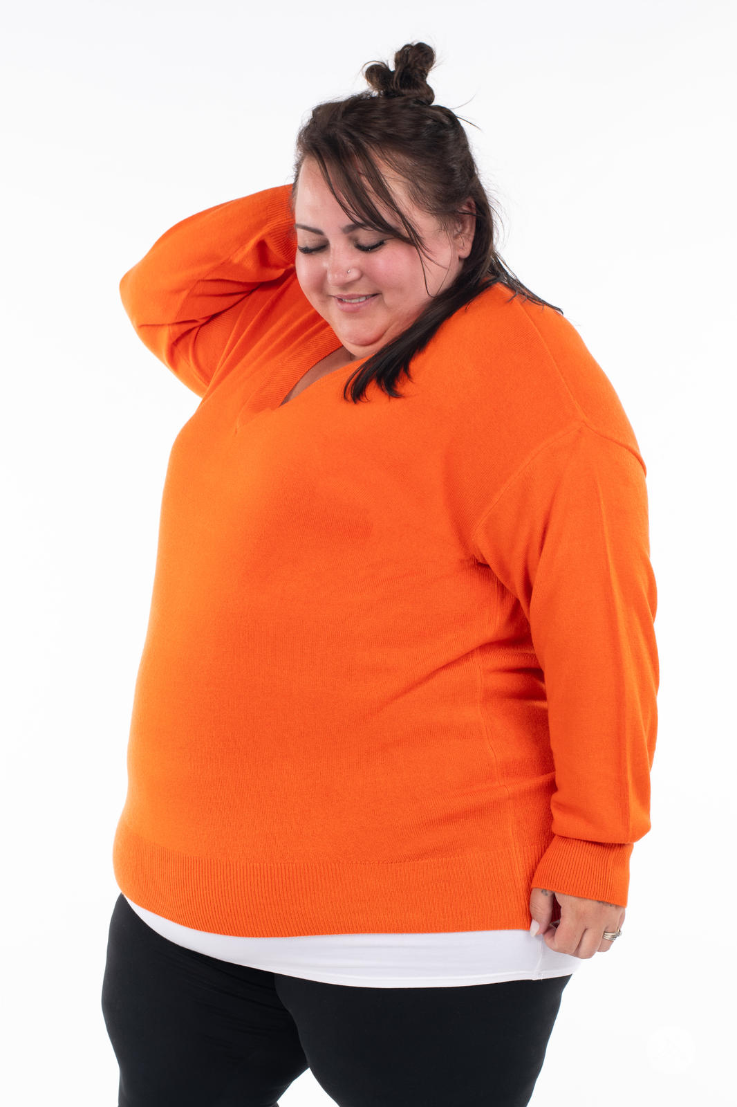 Plus size model wearing SweetTops Soft Knit V-Neck Sweater in vibrant orange with relaxed fit and ribbed hem and cuffs