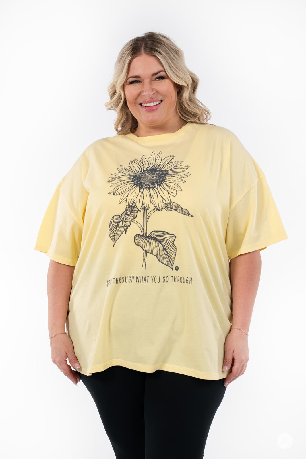 Woman smiling wearing SweetTops Vintage Graphic Tee in pale yellow with sunflower and motivational quote design