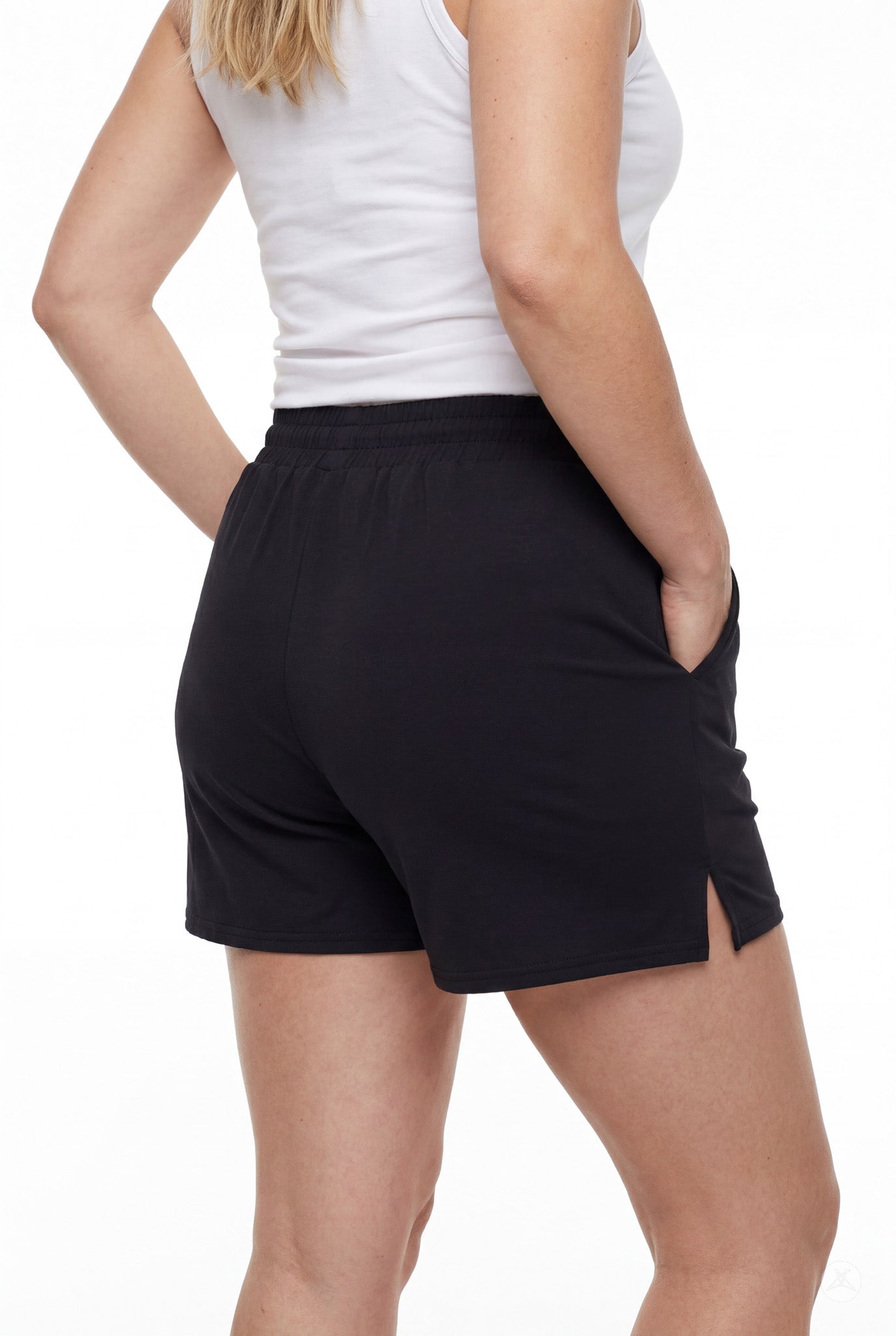 Rear view of person wearing black Lounge Shorts by SweetLegs with elastic waistband and side slits on white background