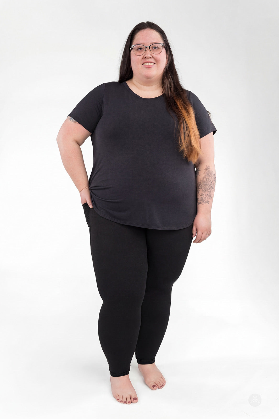 Plus size woman wearing sweetlegs Black Pocket Leggings standing barefoot against a white background