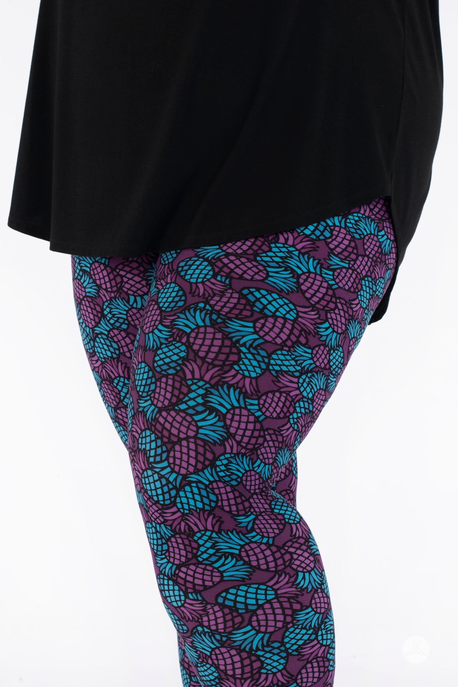 Close-up side view of SweetLegs Razzle Dazzle Crops in purple with turquoise pineapple print on cropped leggings