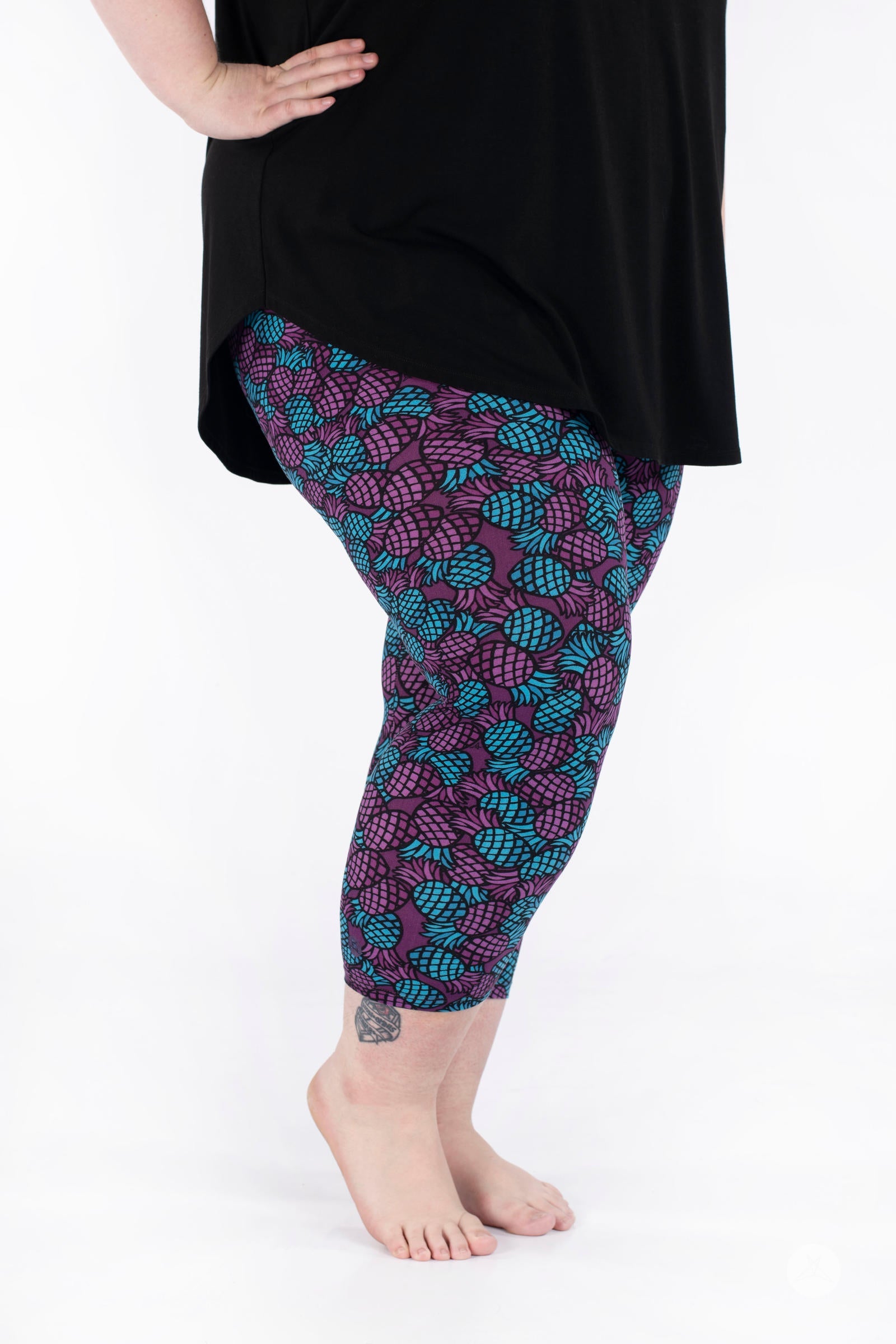 Side view of SweetLegs Razzle Dazzle Crops featuring purple and teal pineapple pattern on cropped leggings