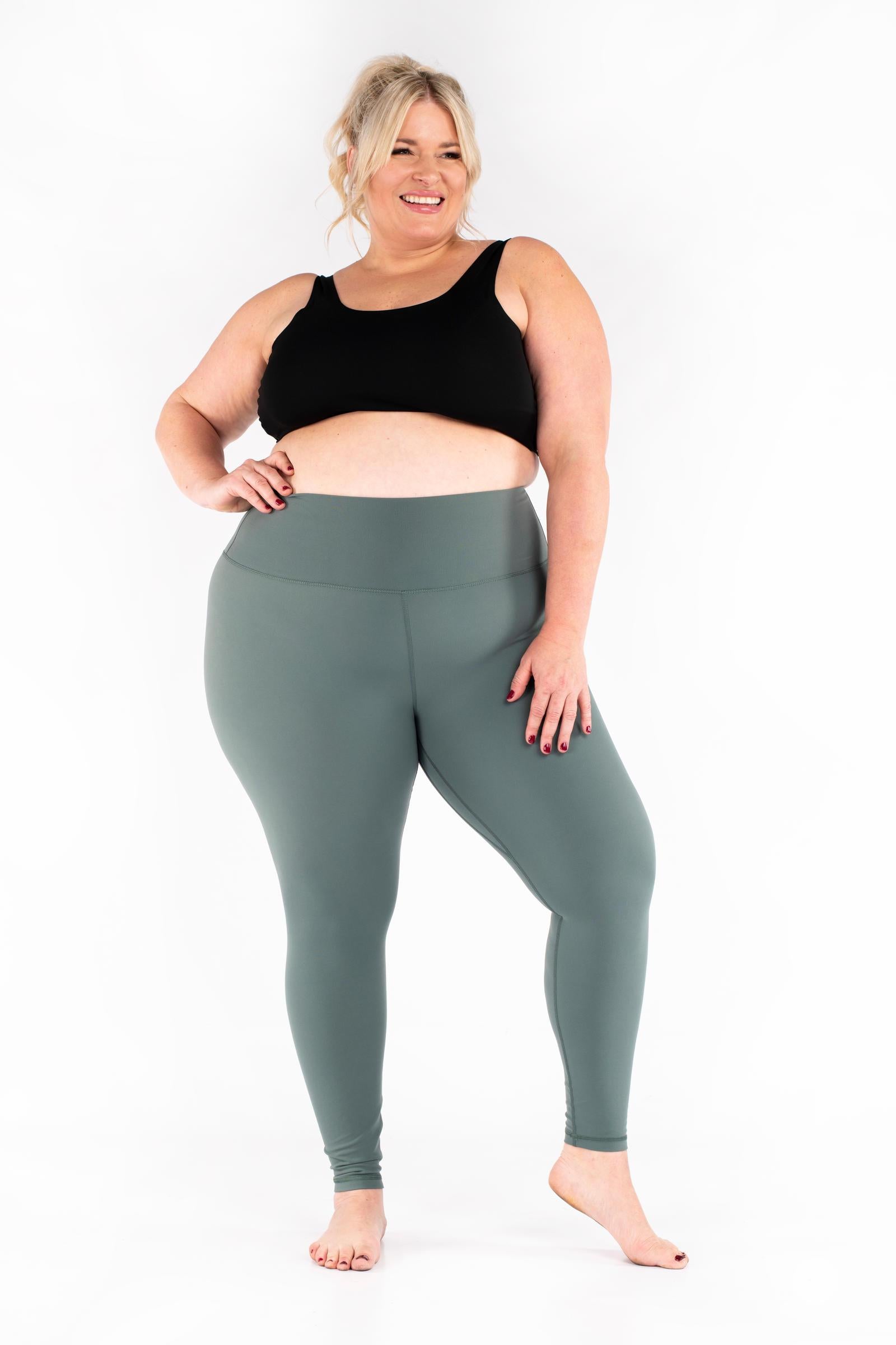 Plus-size woman wearing green Free Motion Leggings from SweetLegs Athleisure smiling barefoot front view