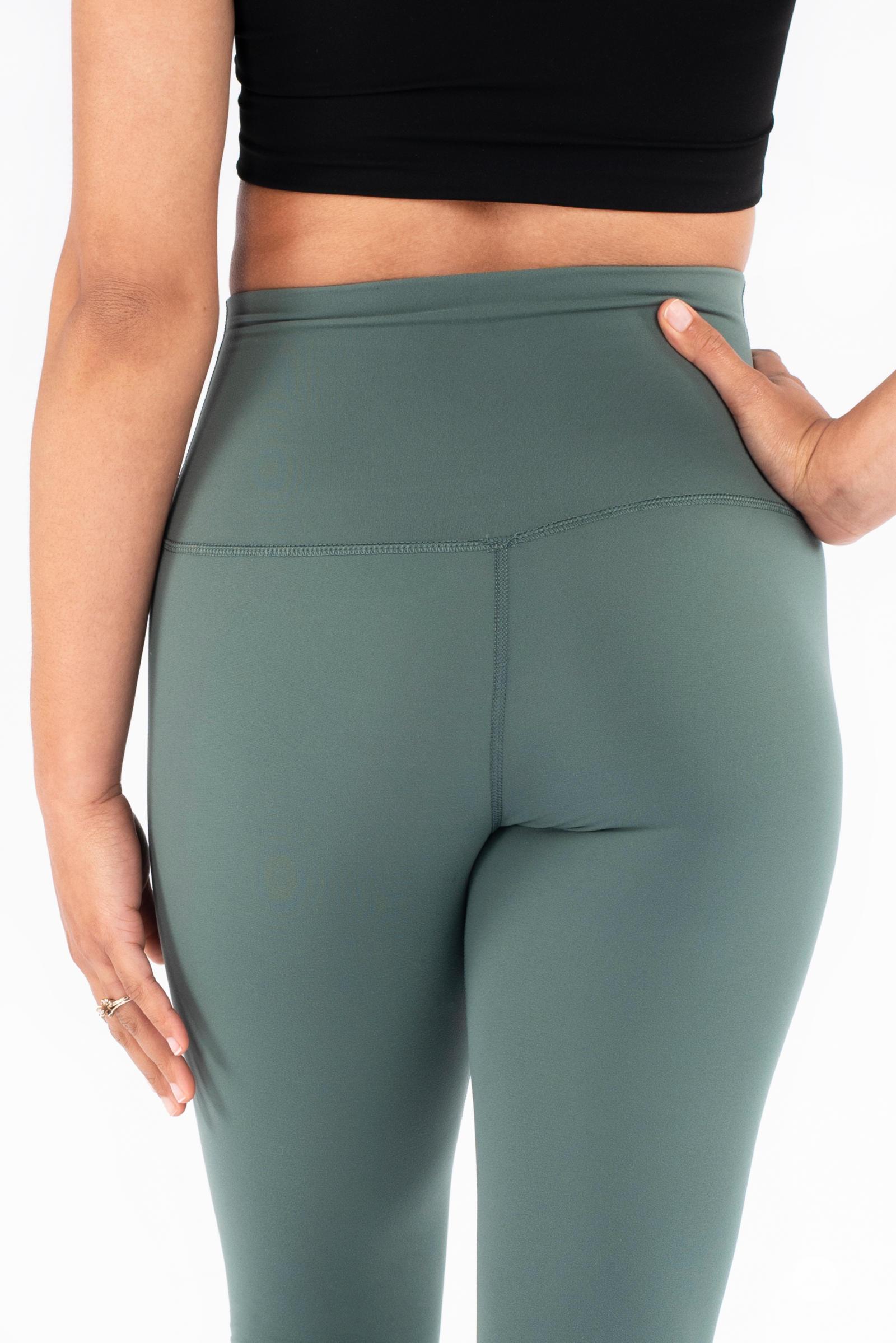 Close up of woman wearing green Free Motion Leggings by SweetLegs Athleisure showing high waistband and seam details