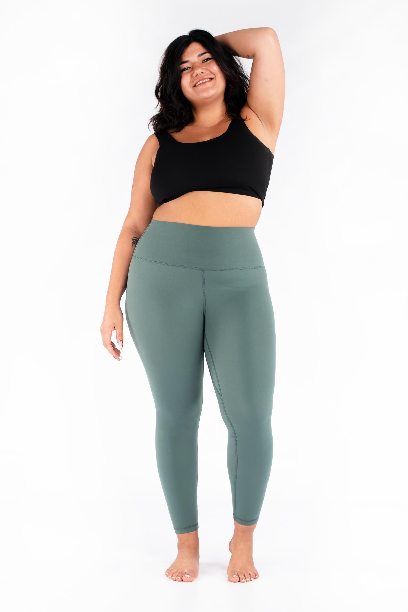 Plus-size woman smiling wearing green Free Motion Leggings from SweetLegs Athleisure standing barefoot front view