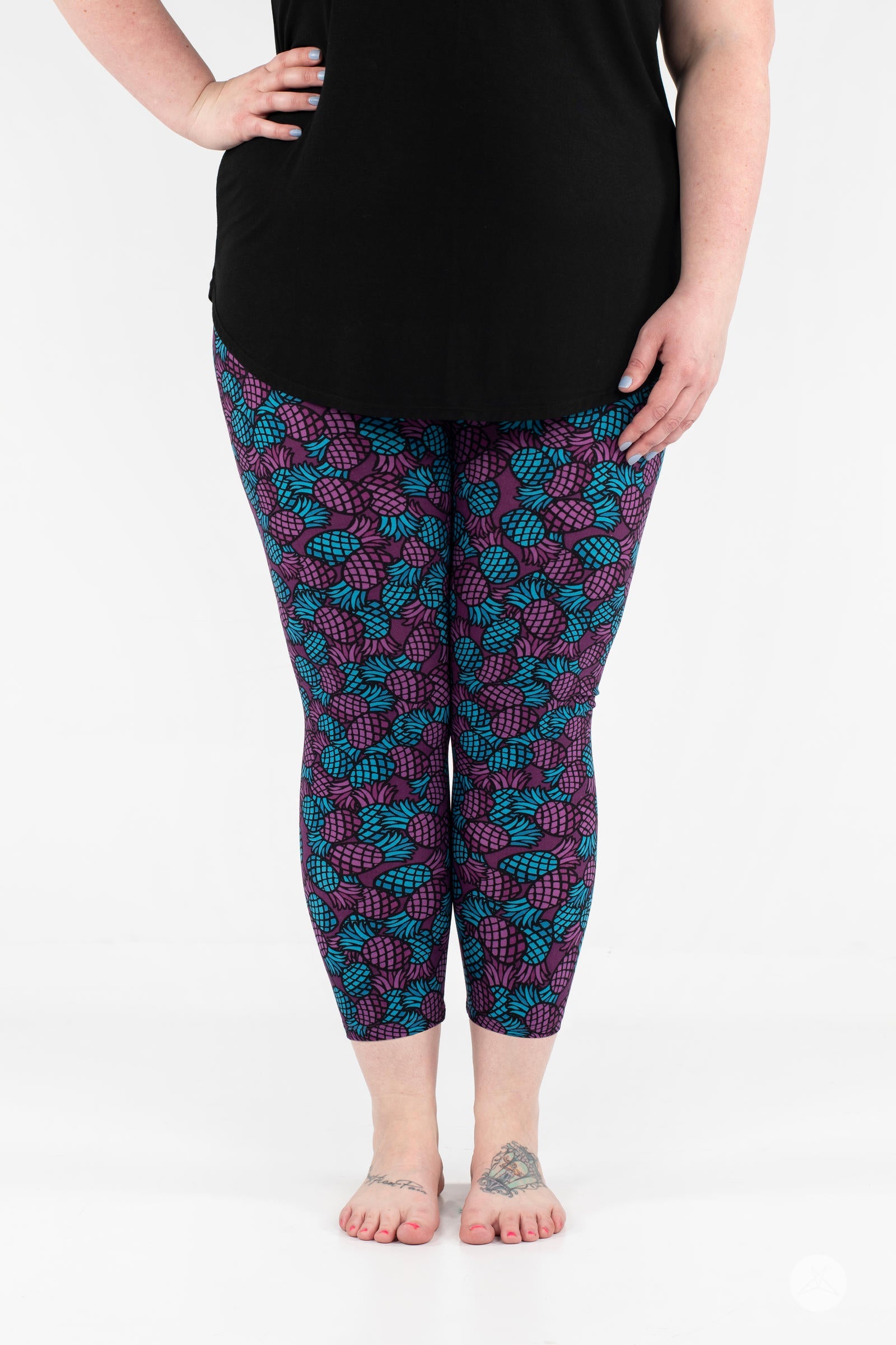 Front view of SweetLegs Razzle Dazzle Crops in purple and teal pineapple print cropped leggings on model