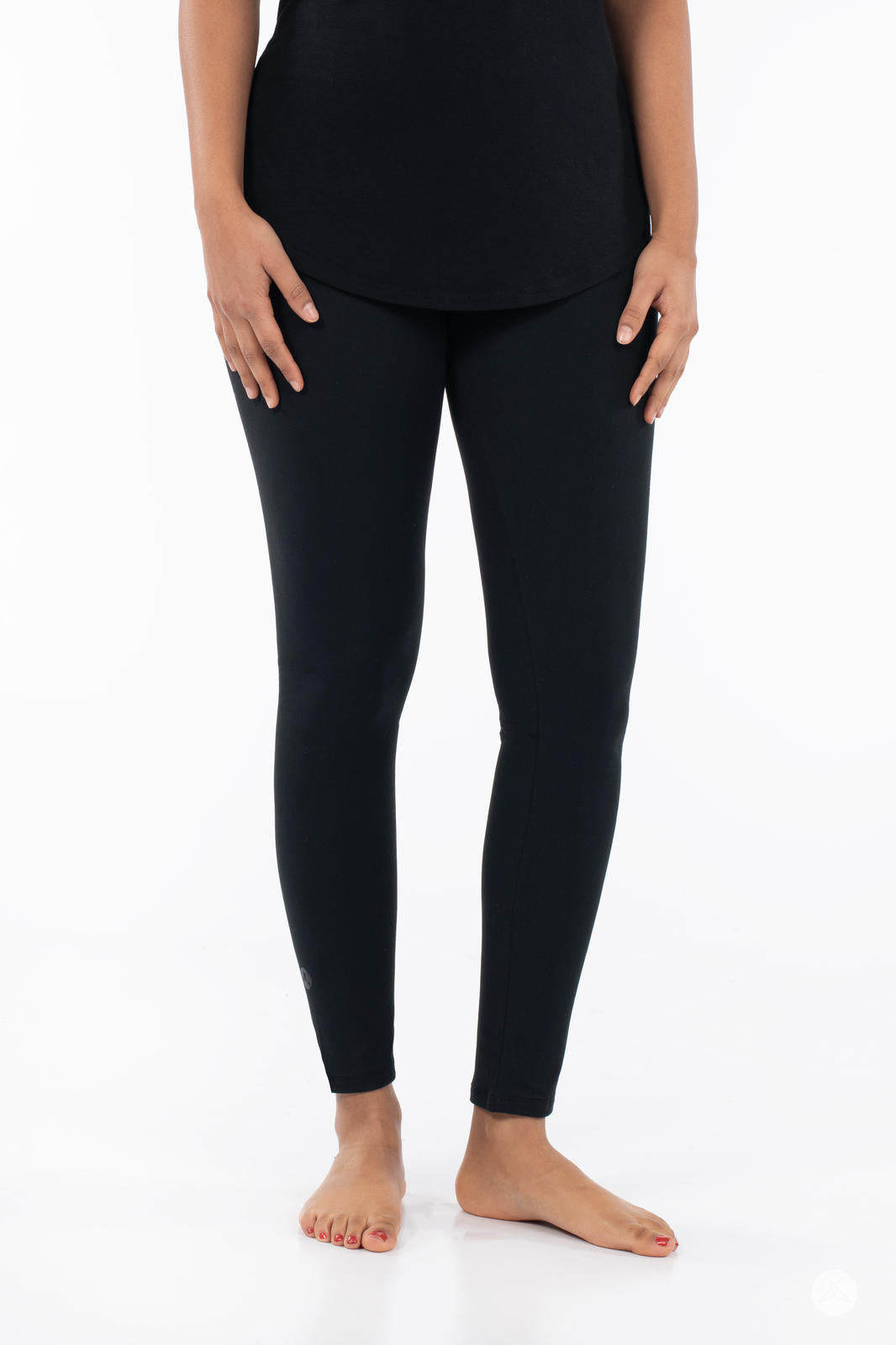 Front view of adult wearing SweetLegs Black Licorice leggings paired with black top barefoot on white background