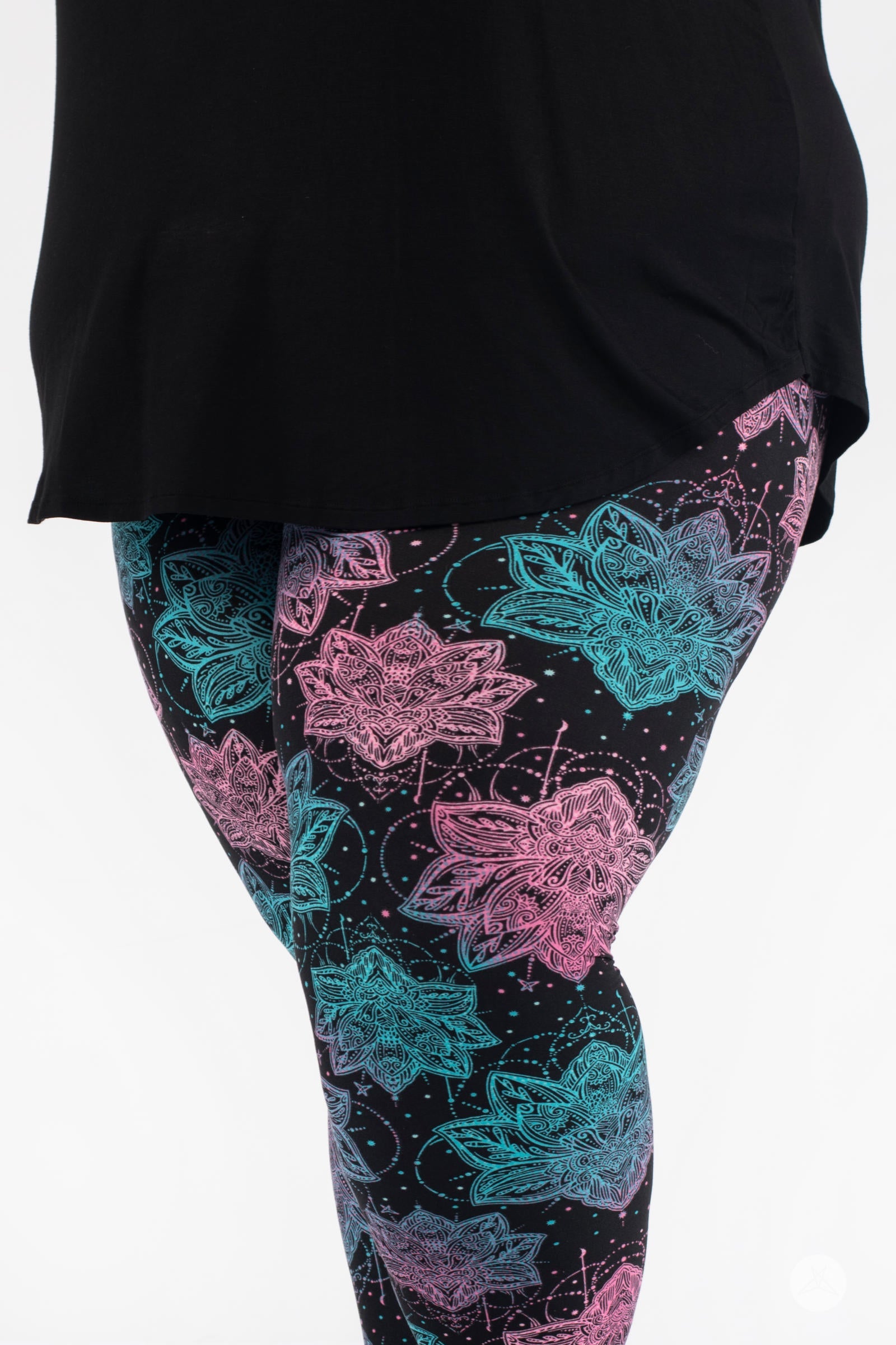 Close-up side view of SweetLegs Everafter Crops with pink and teal floral designs on black background