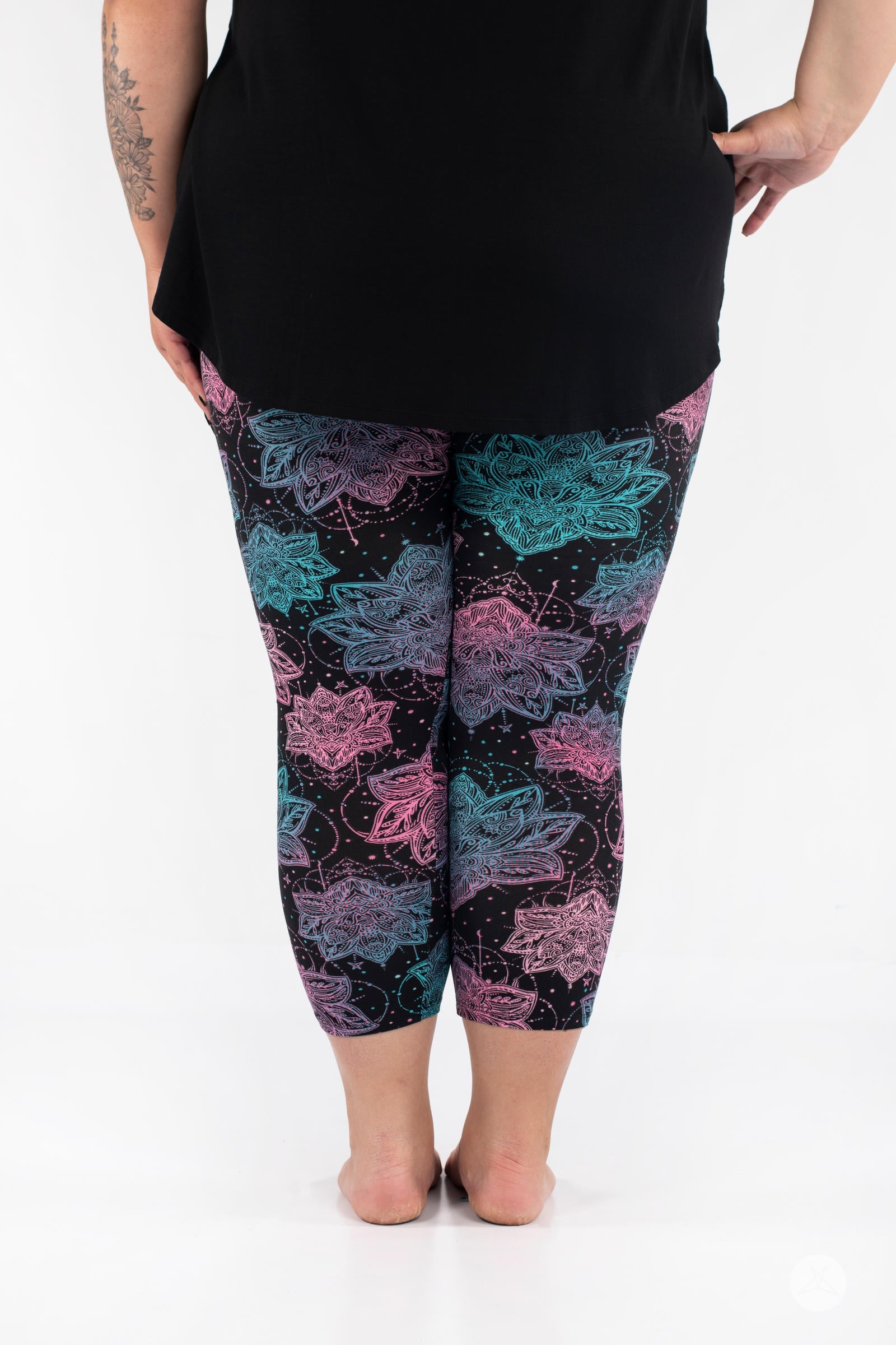 Rear view of SweetLegs Everafter Crops with pink and teal floral pattern on black background worn by model