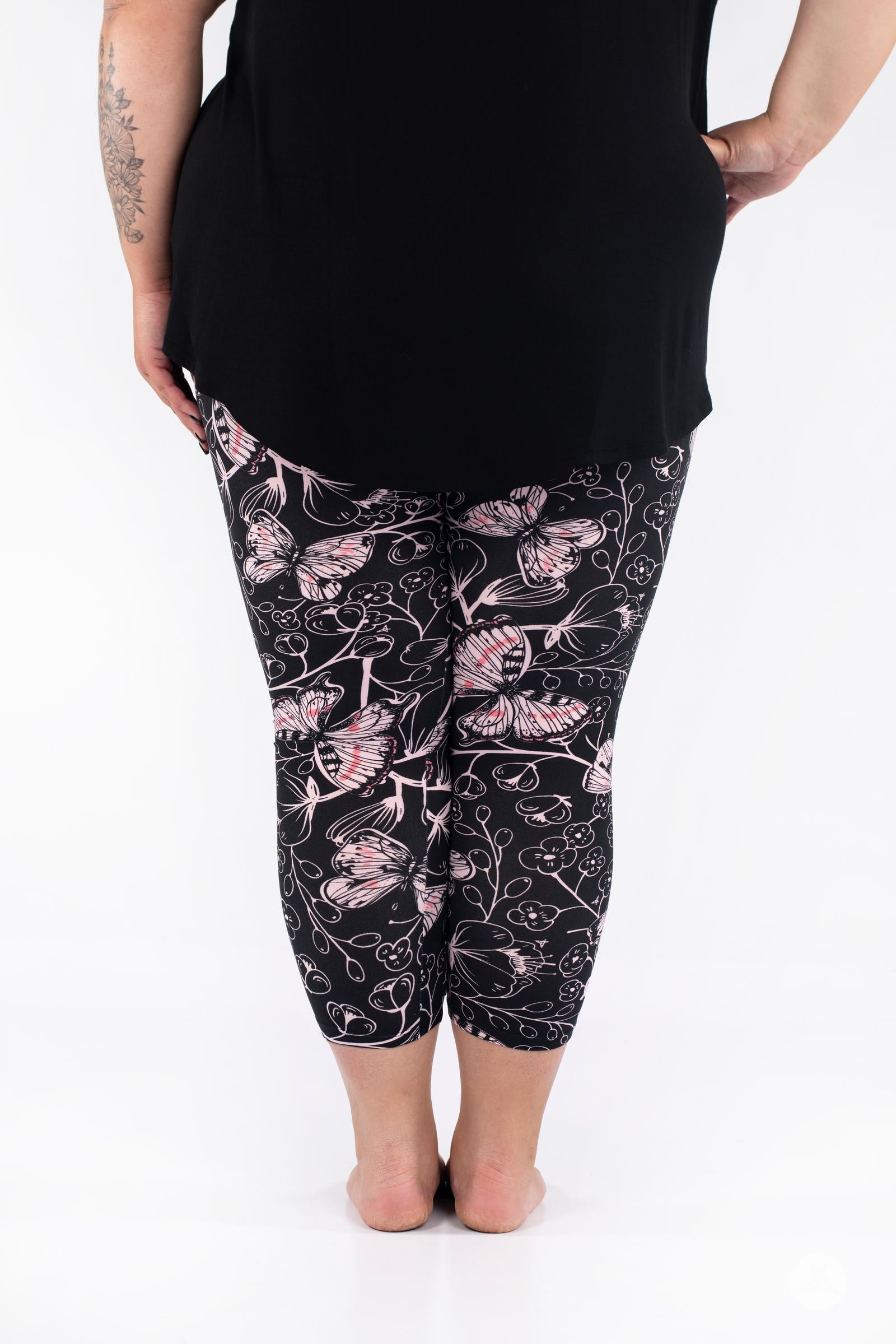 Rear view of plus-size model wearing SweetLegs Butterfly Bliss 2.0 Crops with pink butterfly print and black top