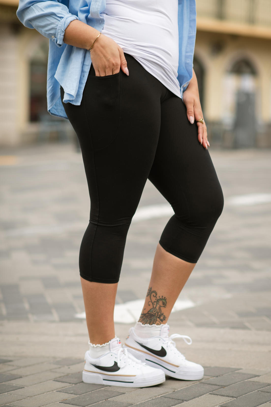 Side view of woman wearing SweetLegs High-Waist Pocket Crops in black with hand in pocket outdoors