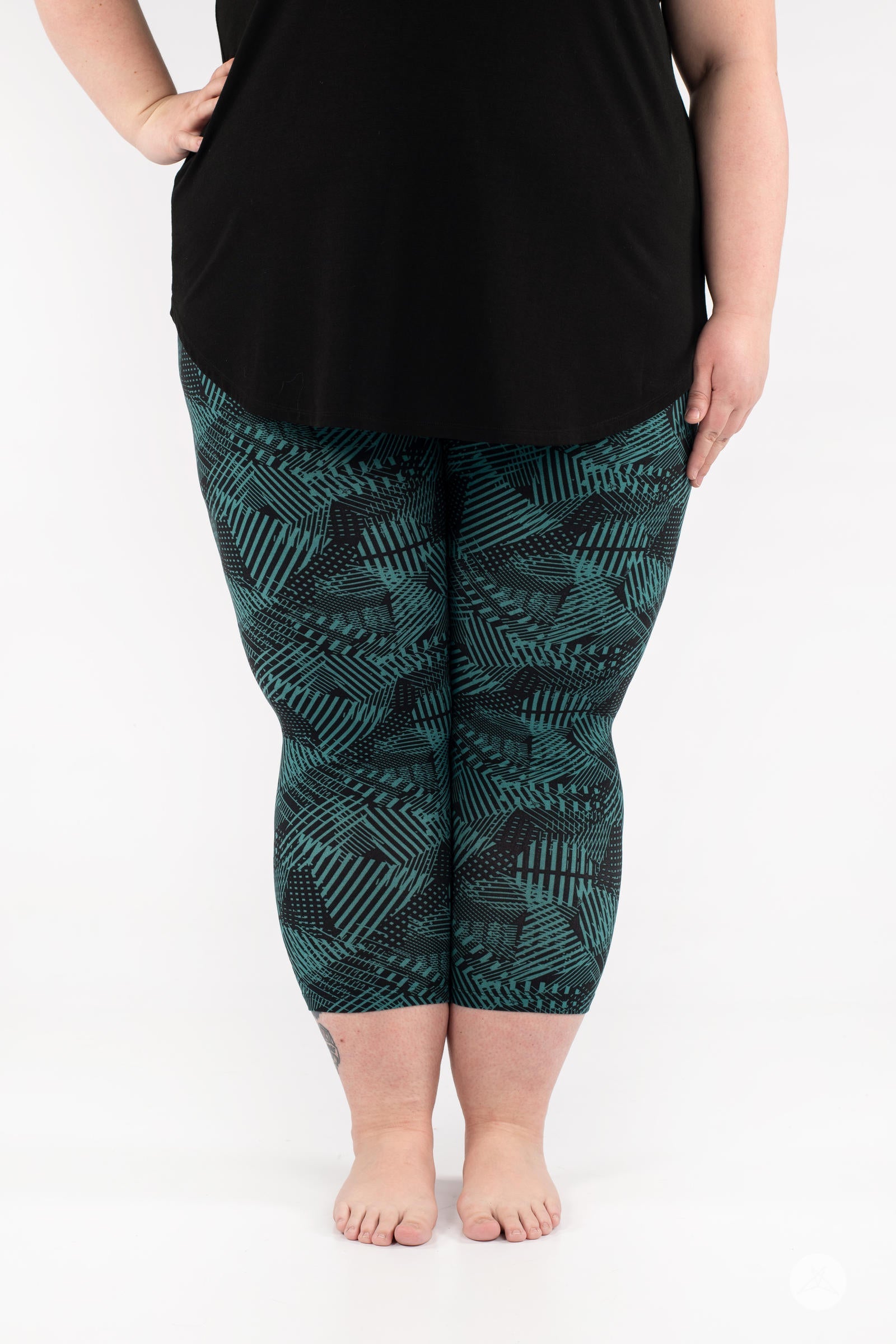 Front view of model wearing SweetLegs Geometric Glam Crops with green and black abstract patterned cropped leggings