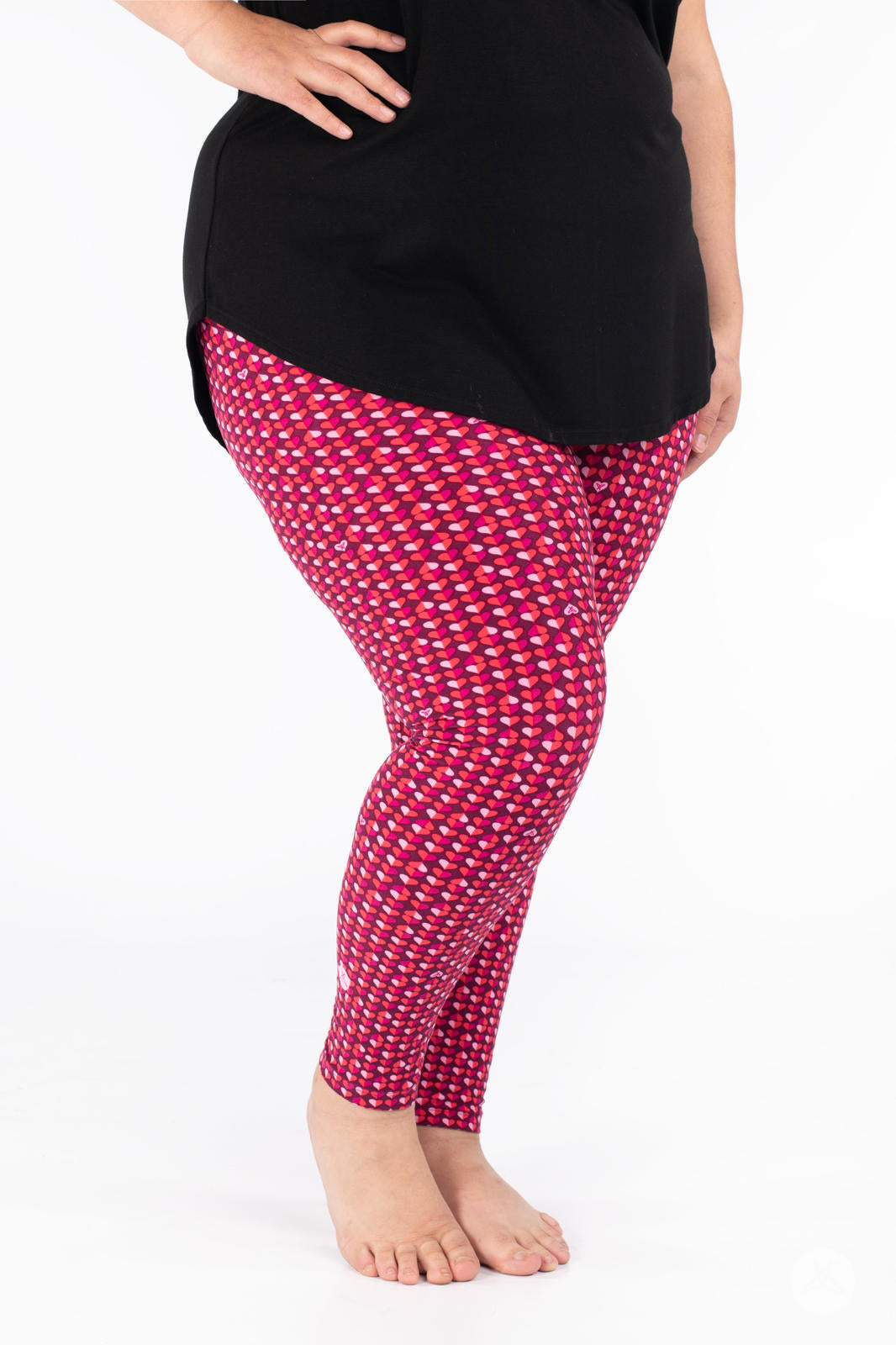 Side angle of SweetLegs Lovesick leggings featuring small duo-colored hearts in pink and purple worn barefoot