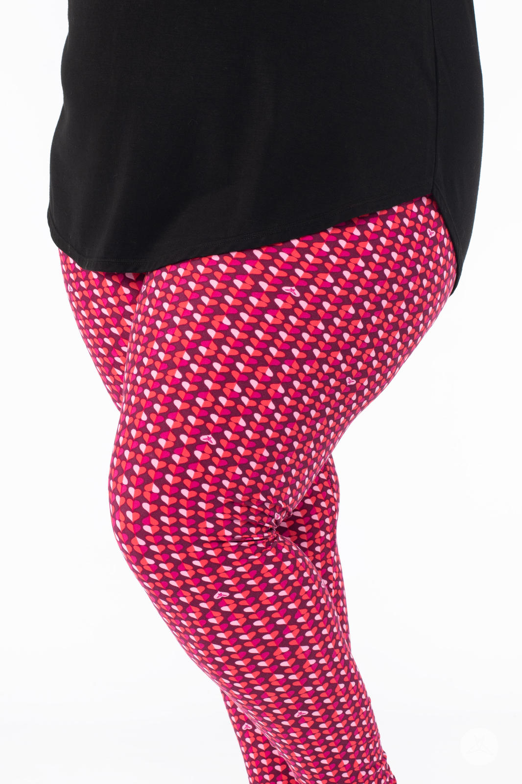Close-up side view of SweetLegs Lovesick leggings featuring small pink and purple duo-colored hearts worn with black top