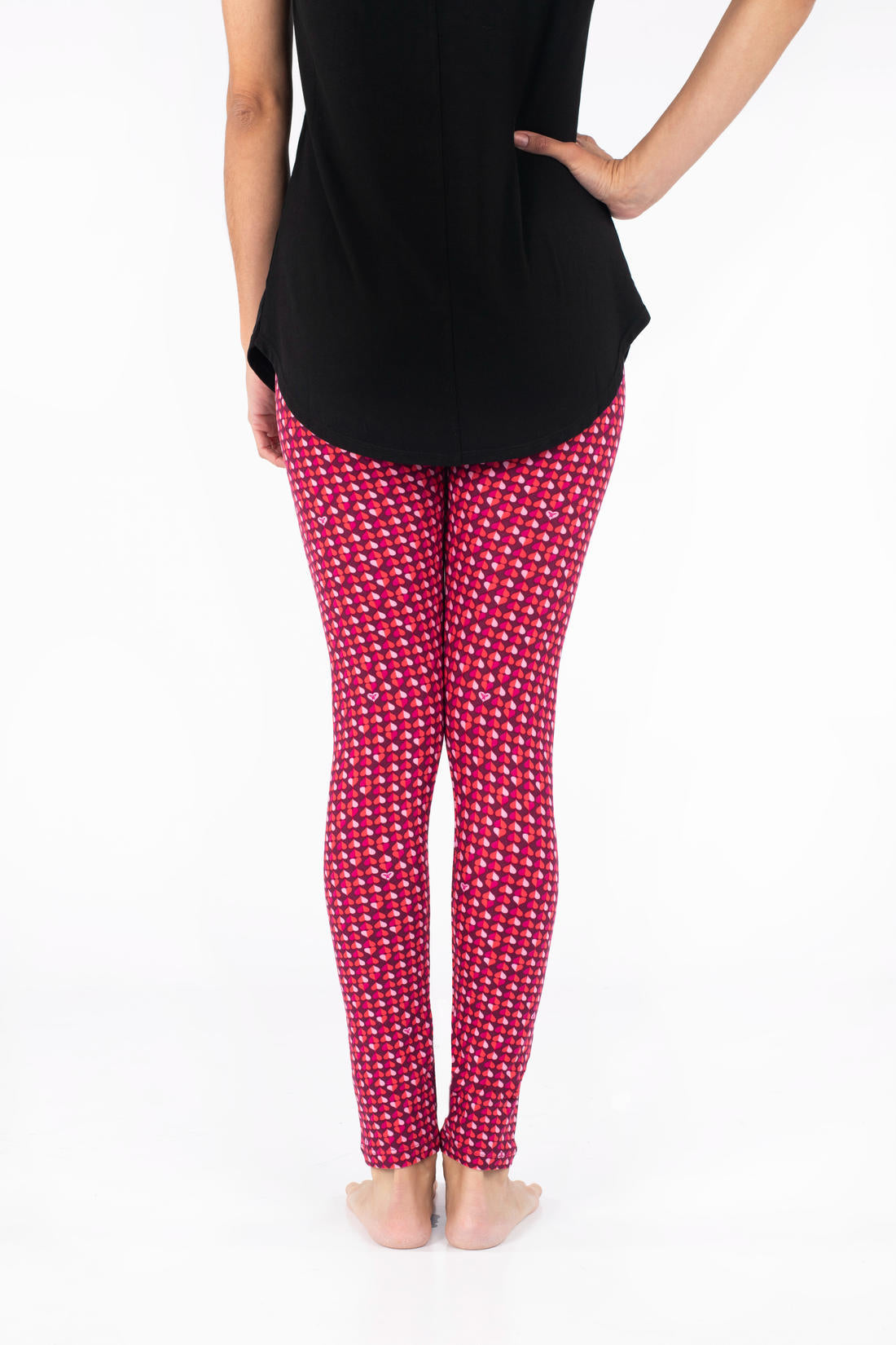 Rear view of SweetLegs Lovesick leggings in bright pink with small duo-colored heart pattern worn barefoot