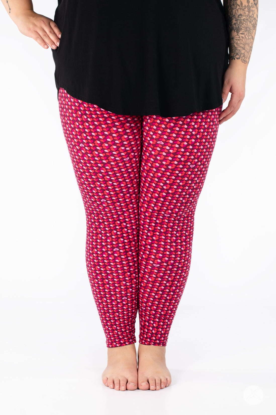 Front view of SweetLegs Lovesick leggings featuring vibrant repeating pink and purple duo-colored hearts worn barefoot