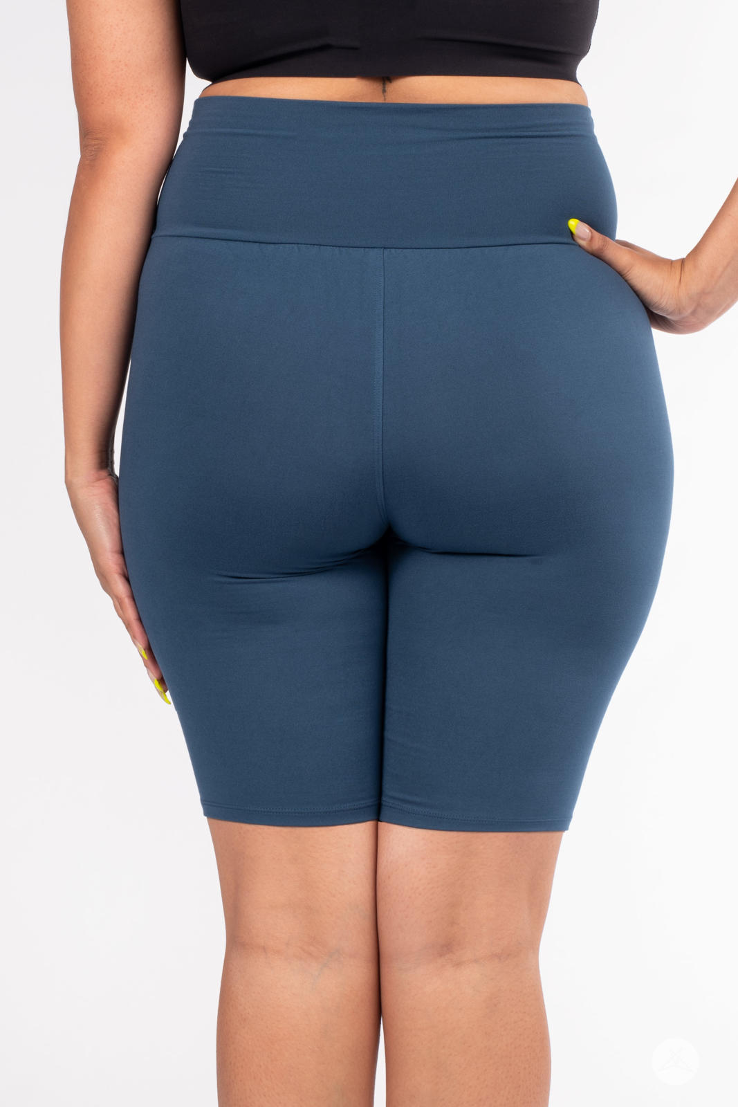 Rear view of plus-size model wearing SweetLegs Solid High-Waisted Biker Shorts in deep blue with smooth waistband