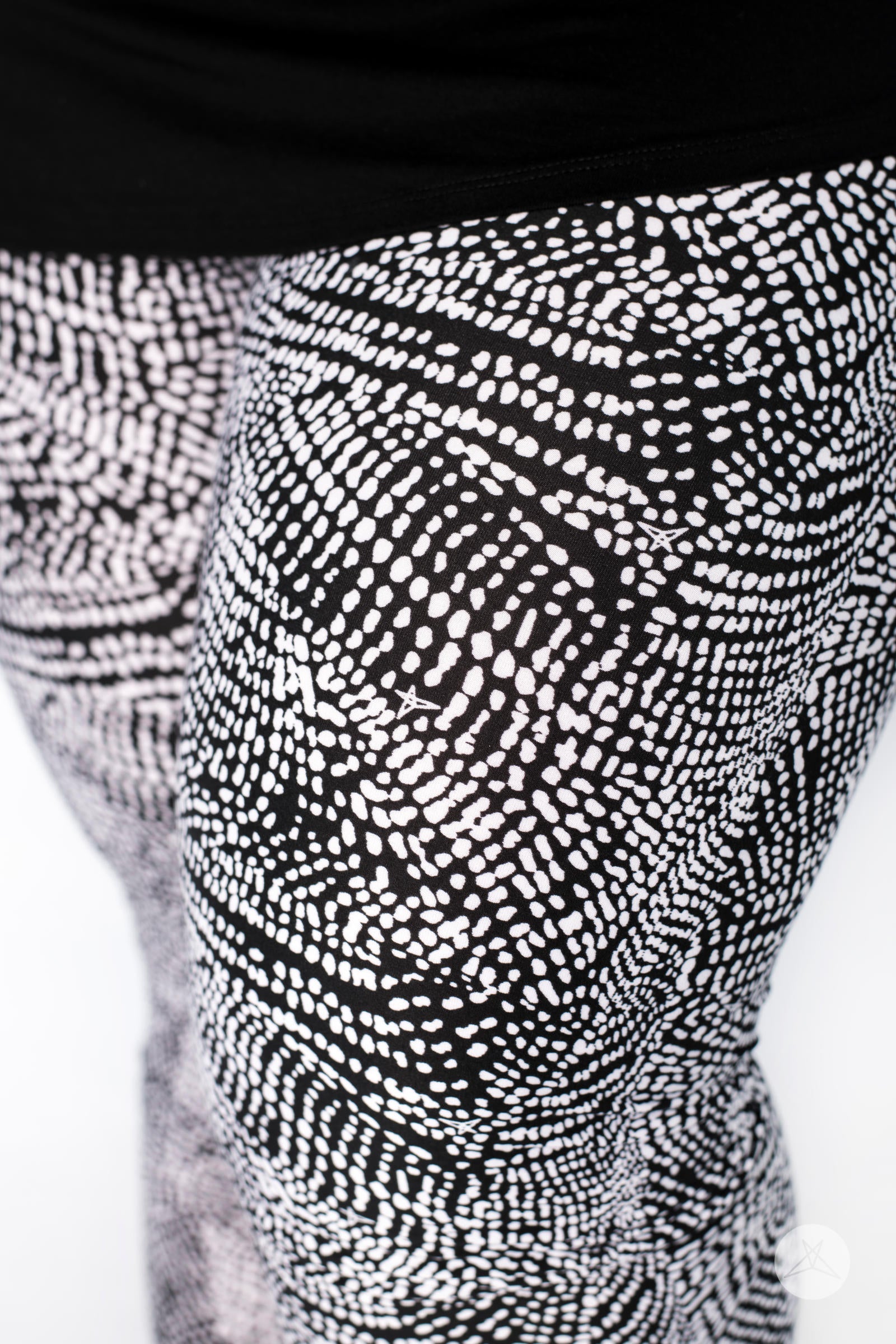 Close-up of SweetLegs Charmed leggings featuring black and white abstract deconstructed snakeskin pattern on model legs