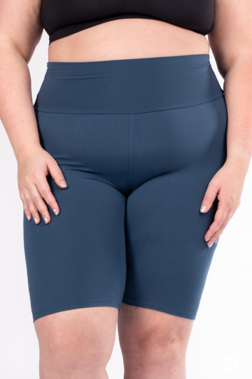Plus-size model wearing SweetLegs Solid High-Waisted Biker Shorts in rich blue with a wide supportive waistband
