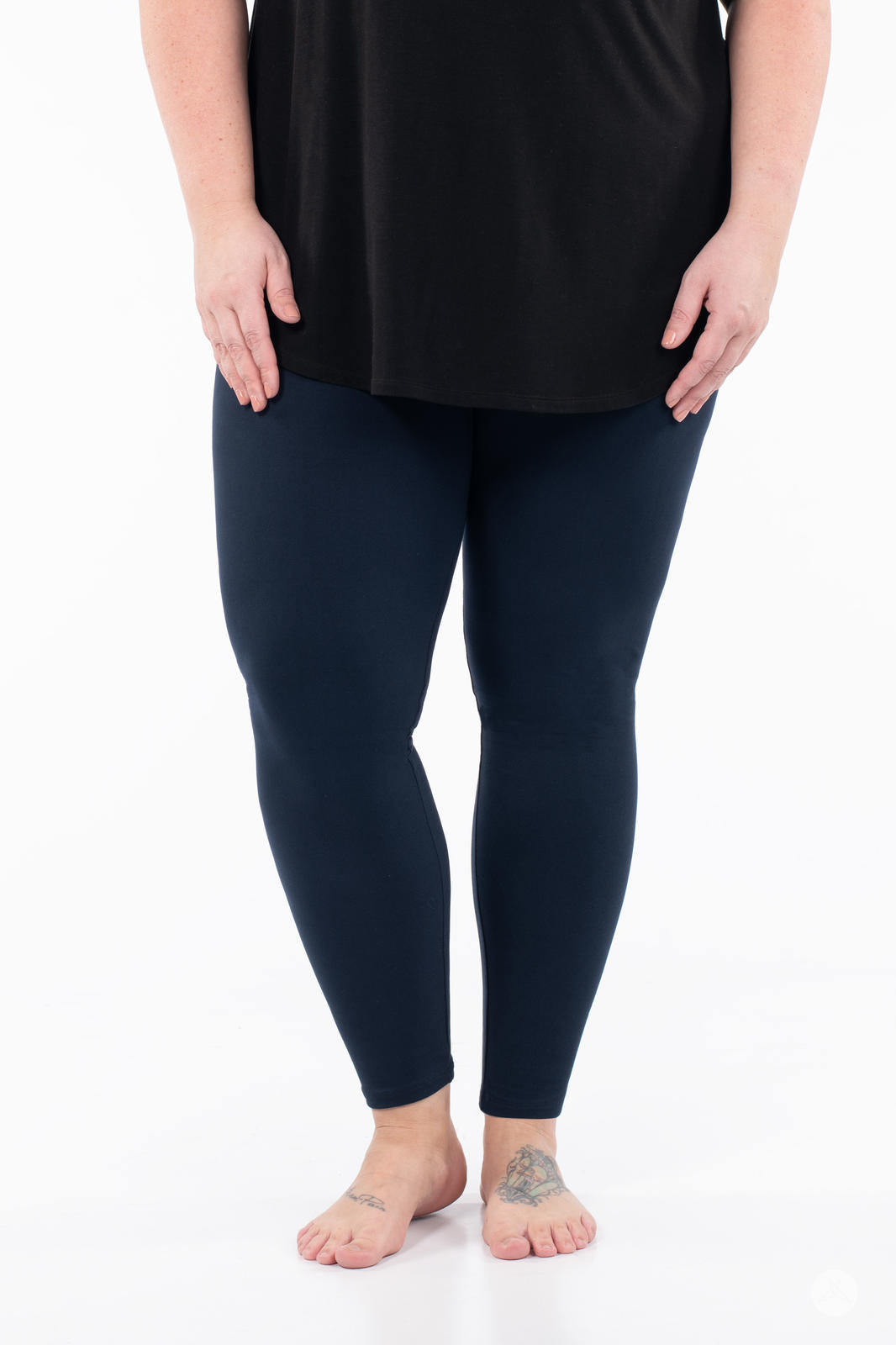 Front view of person wearing Navy leggings by SweetLegs paired with black top standing barefoot on white background