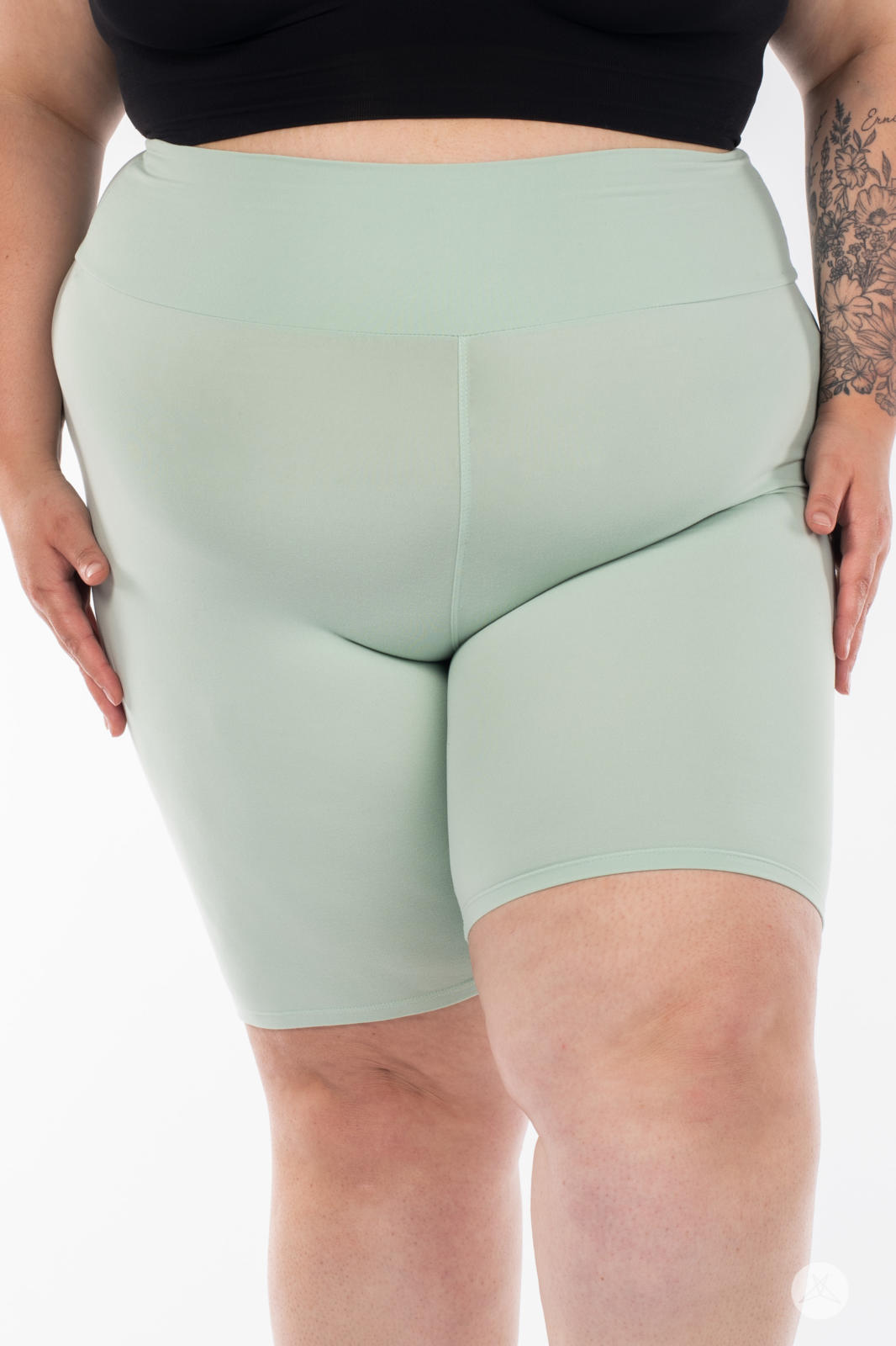 Close-up of plus-size model wearing SweetLegs Solid High-Waisted Biker Shorts in soft mint with a smooth waistband