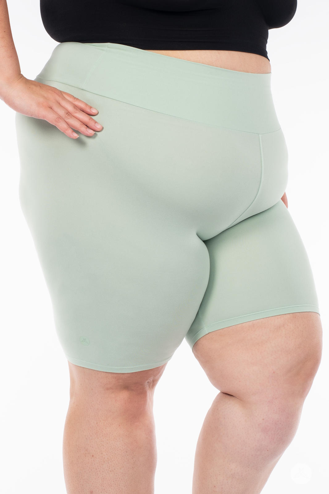 Plus-size model wearing SweetLegs Solid High-Waisted Biker Shorts in soft mint with a smooth, wide waistband