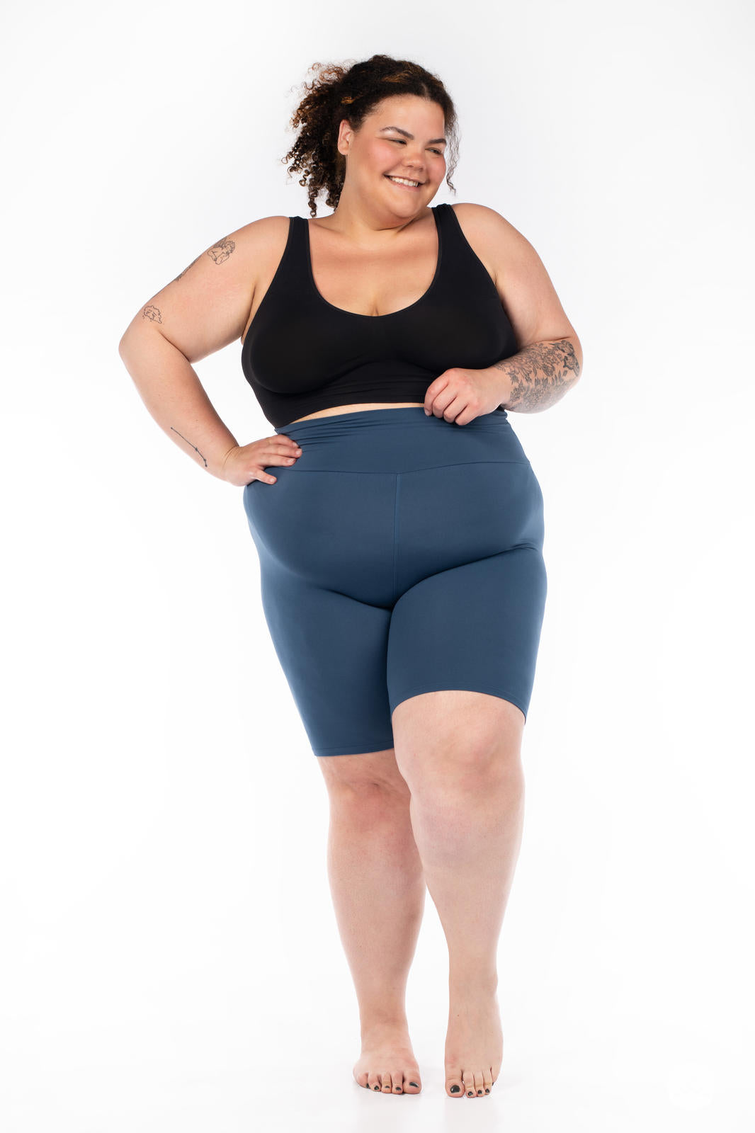 Plus-size model wearing SweetLegs Solid High-Waisted Biker Shorts in deep blue with a flattering high-rise waistband