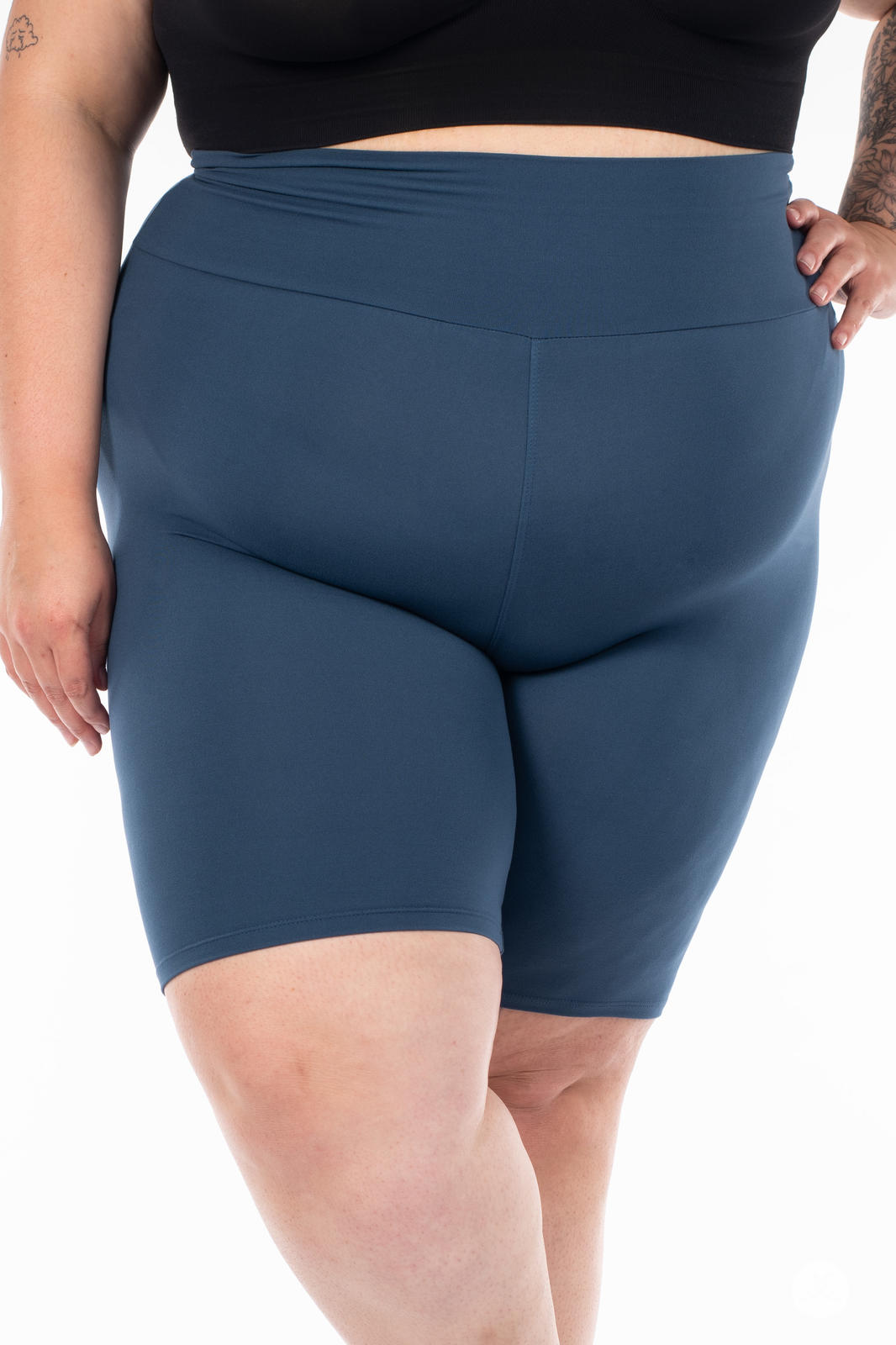 Close-up of plus-size model wearing SweetLegs Solid High-Waisted Biker Shorts in muted blue with a smooth high-rise waistband