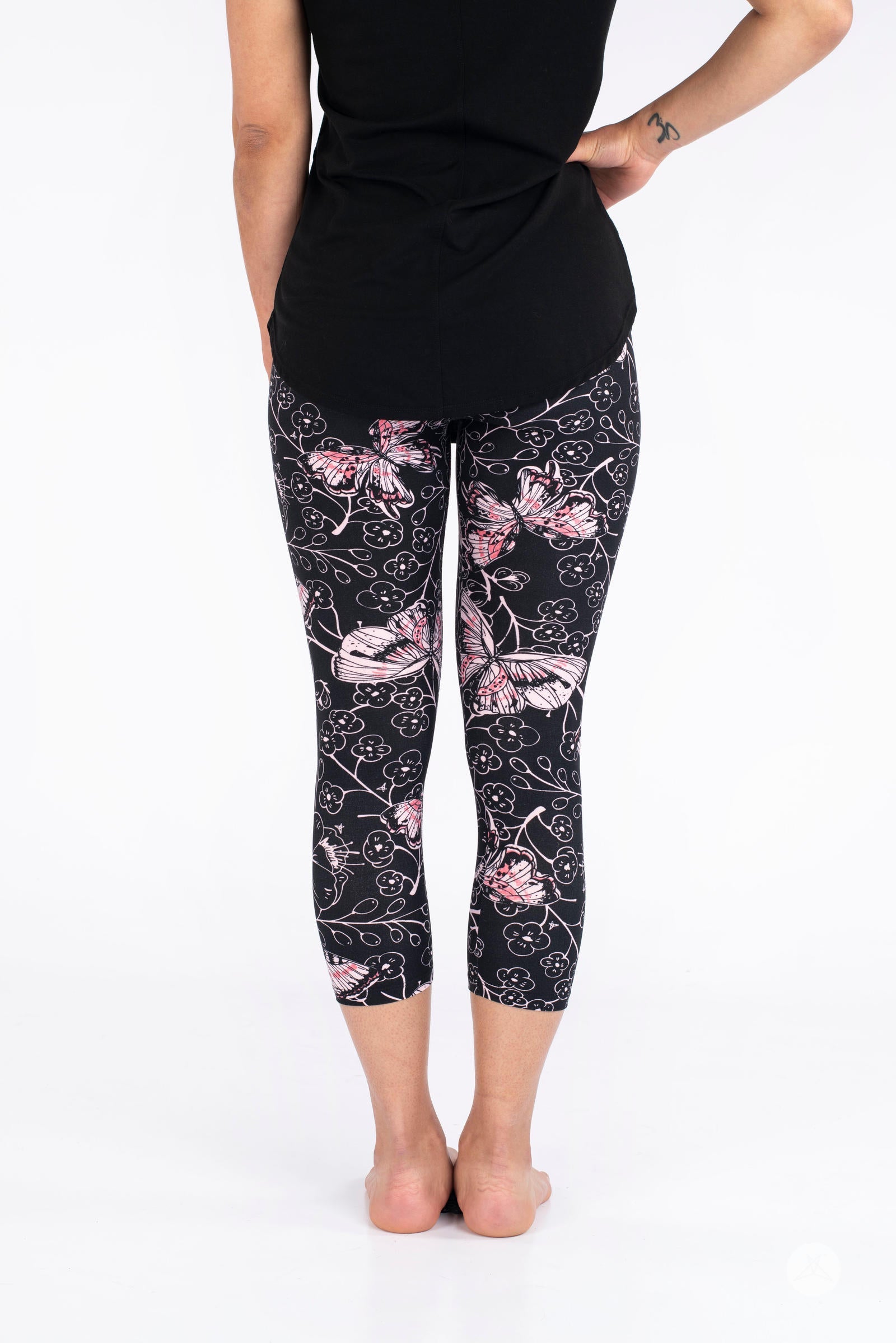 Rear view of SweetLegs Butterfly Bliss 2.0 Crops with pink butterfly and floral pattern on black fabric