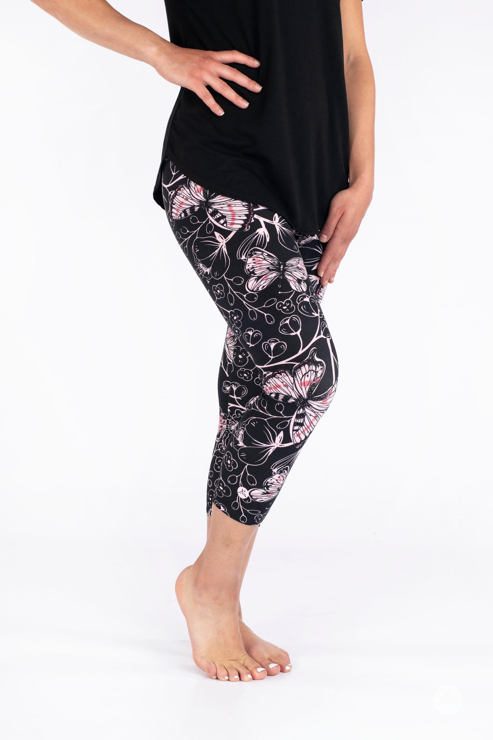 Side view of SweetLegs Butterfly Bliss 2.0 Crops with pink butterfly and floral pattern on black fabric