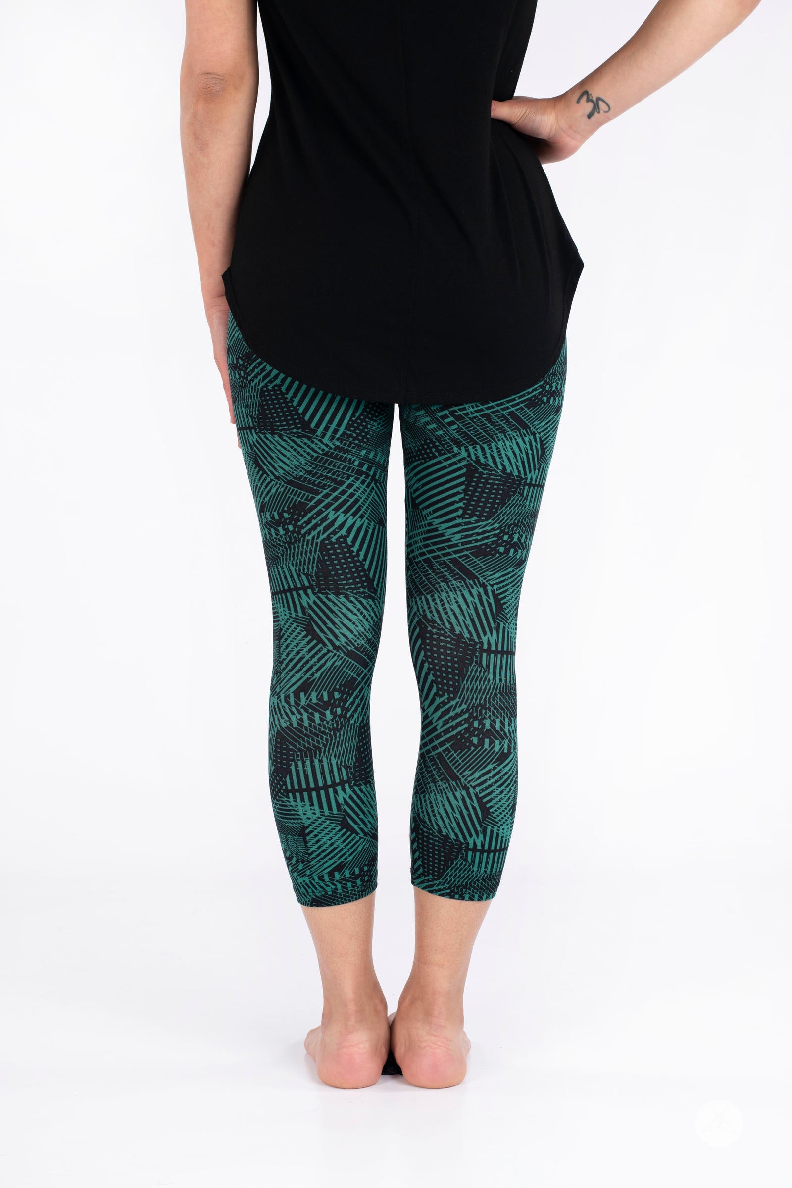 Rear view of SweetLegs Geometric Glam Crops featuring cropped leggings with black and green abstract geometric design