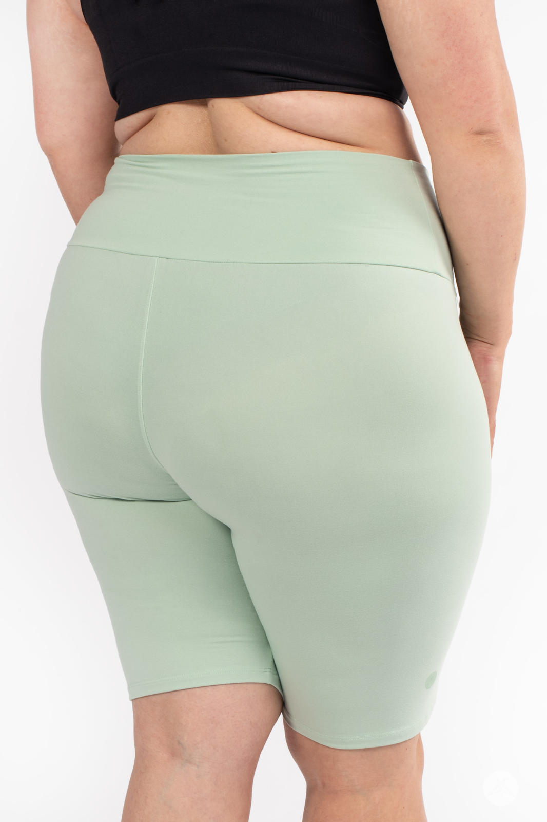 Rear view of plus-size model wearing SweetLegs Solid High-Waisted Biker Shorts in soft mint with a smooth waistband