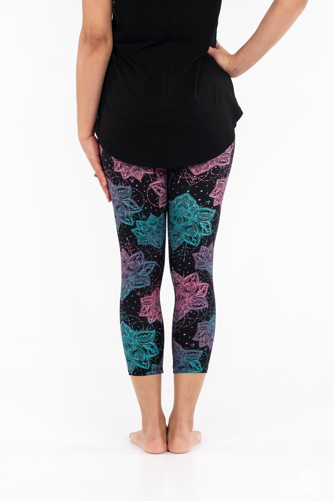 Rear view of SweetLegs Everafter Crops with blue and pink lotus-inspired geometric patterns on black background