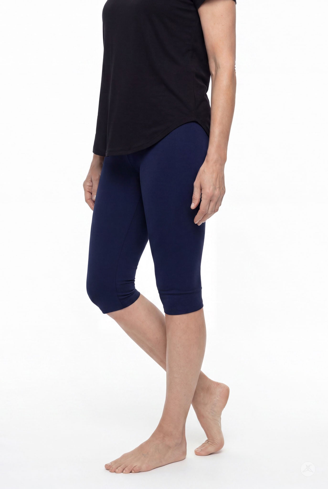 Model wearing SweetLegs Knee-Length Capri in navy blue paired with black top standing barefoot on white background