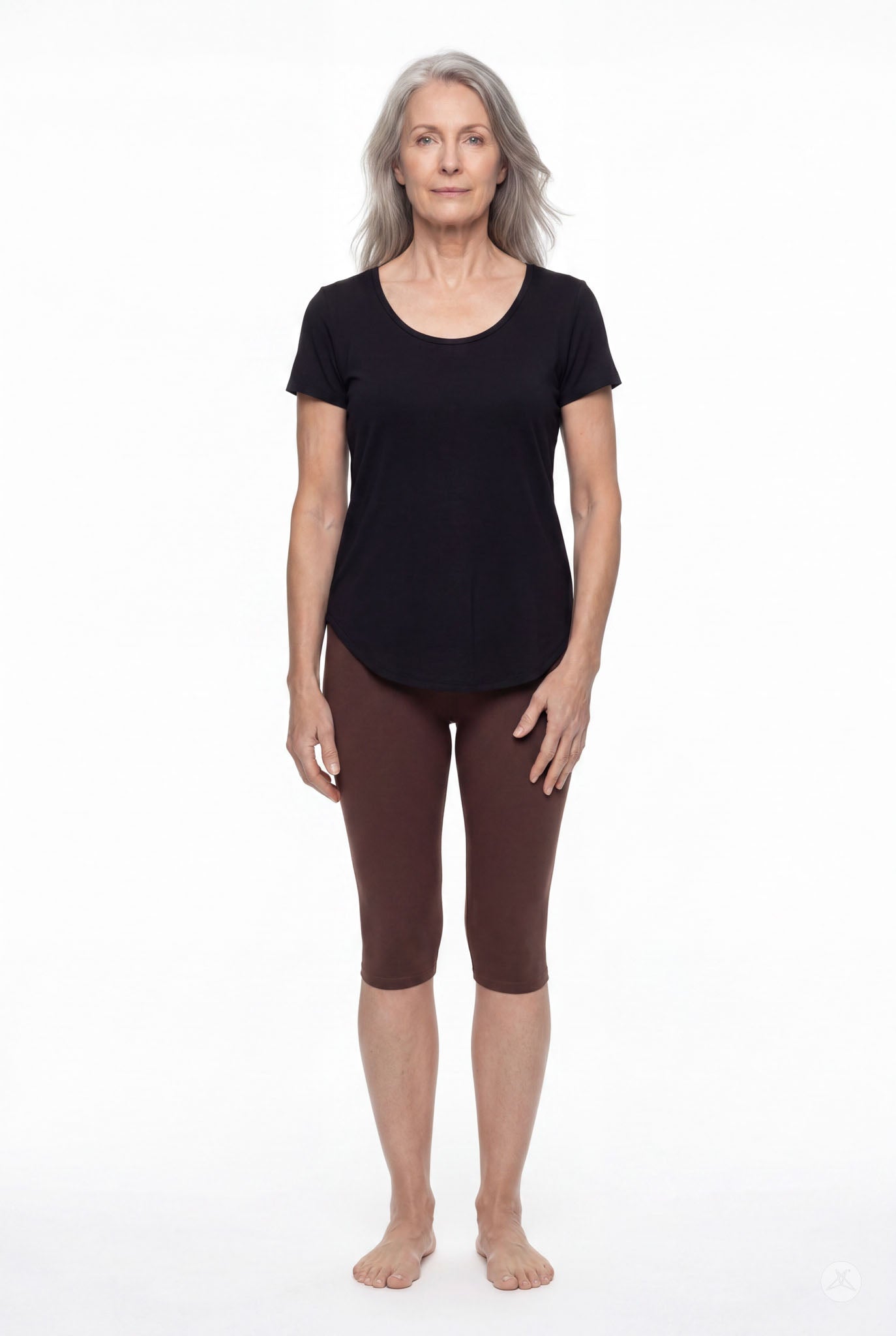 Woman wearing SweetLegs Knee-Length Capri in warm brown with black short sleeve top standing barefoot on white background