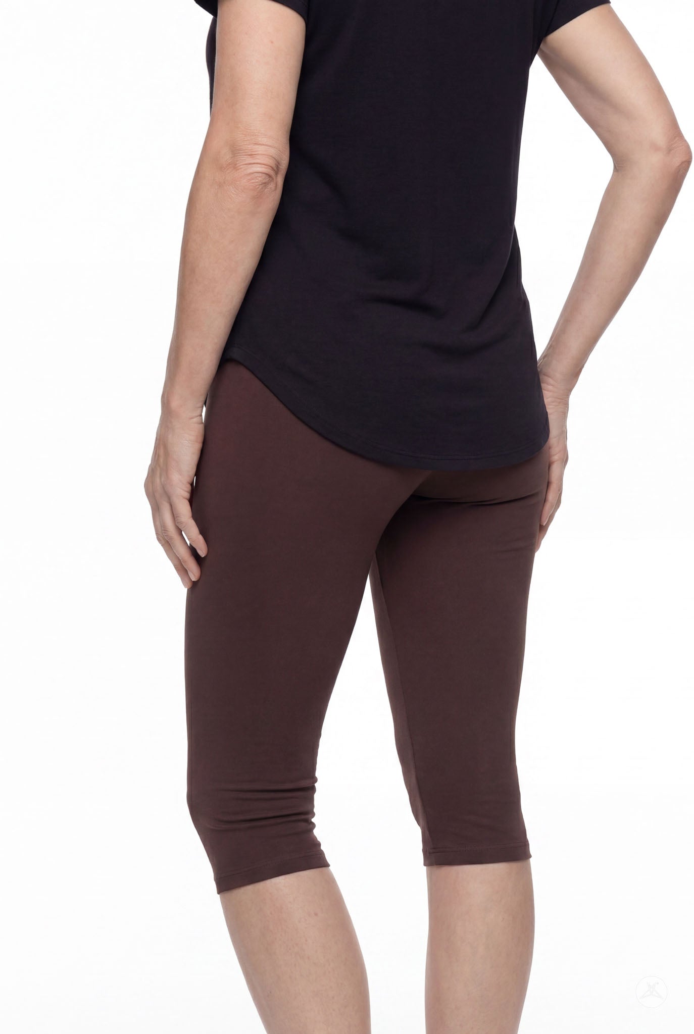 Woman wearing SweetLegs Knee-Length Capri in deep brown with black top shown from back on white background