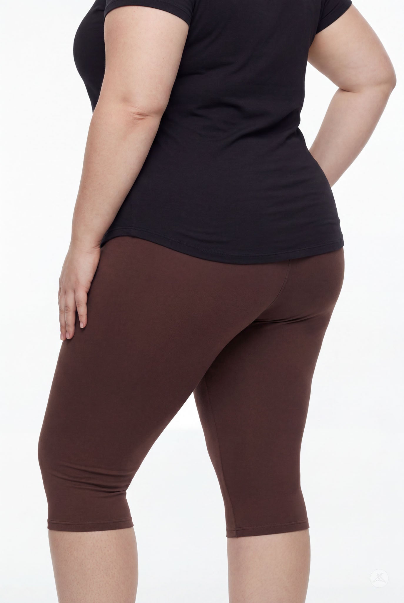 Curvy model wearing SweetLegs Knee-Length Capri in rich walnut brown paired with black top shown from side on white background